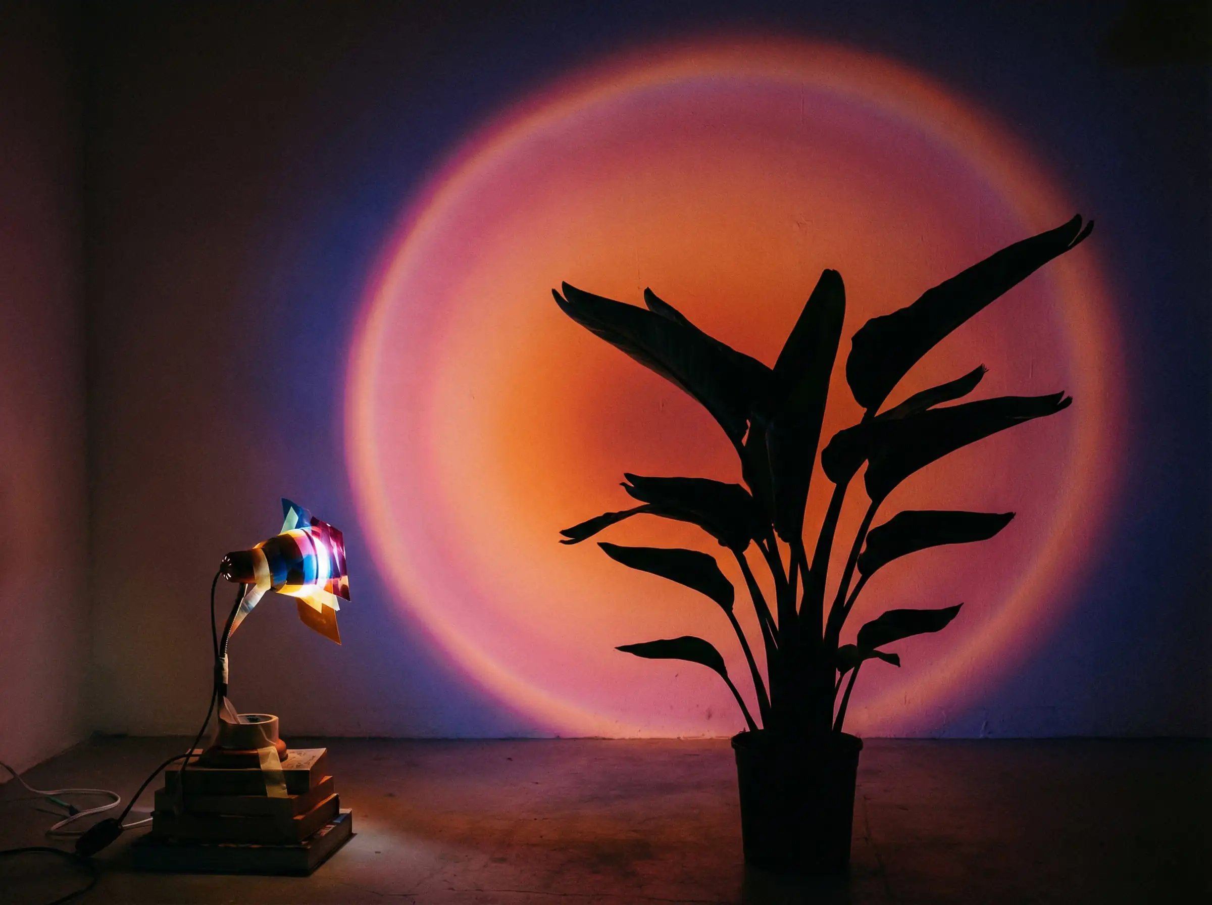 Projection of a sunset color gradient on a white wall created using a flashlight and colored filters.