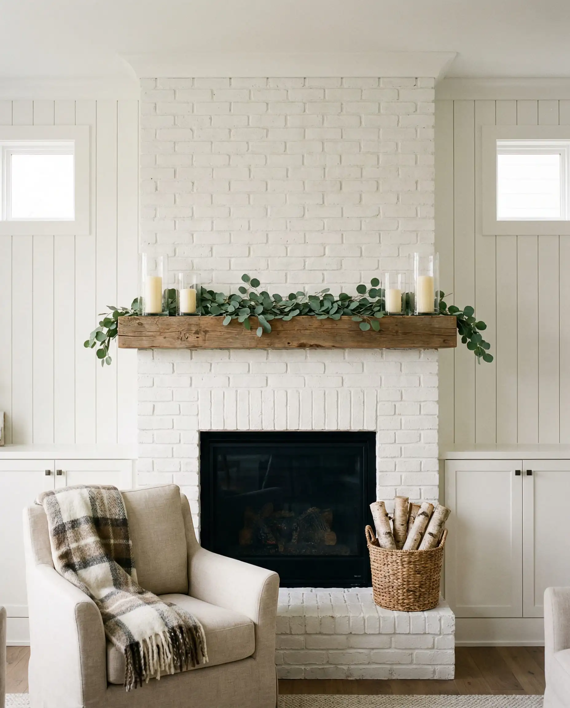 Modern farmhouse living room with white vertical board and batten walls framing a brick fireplace.