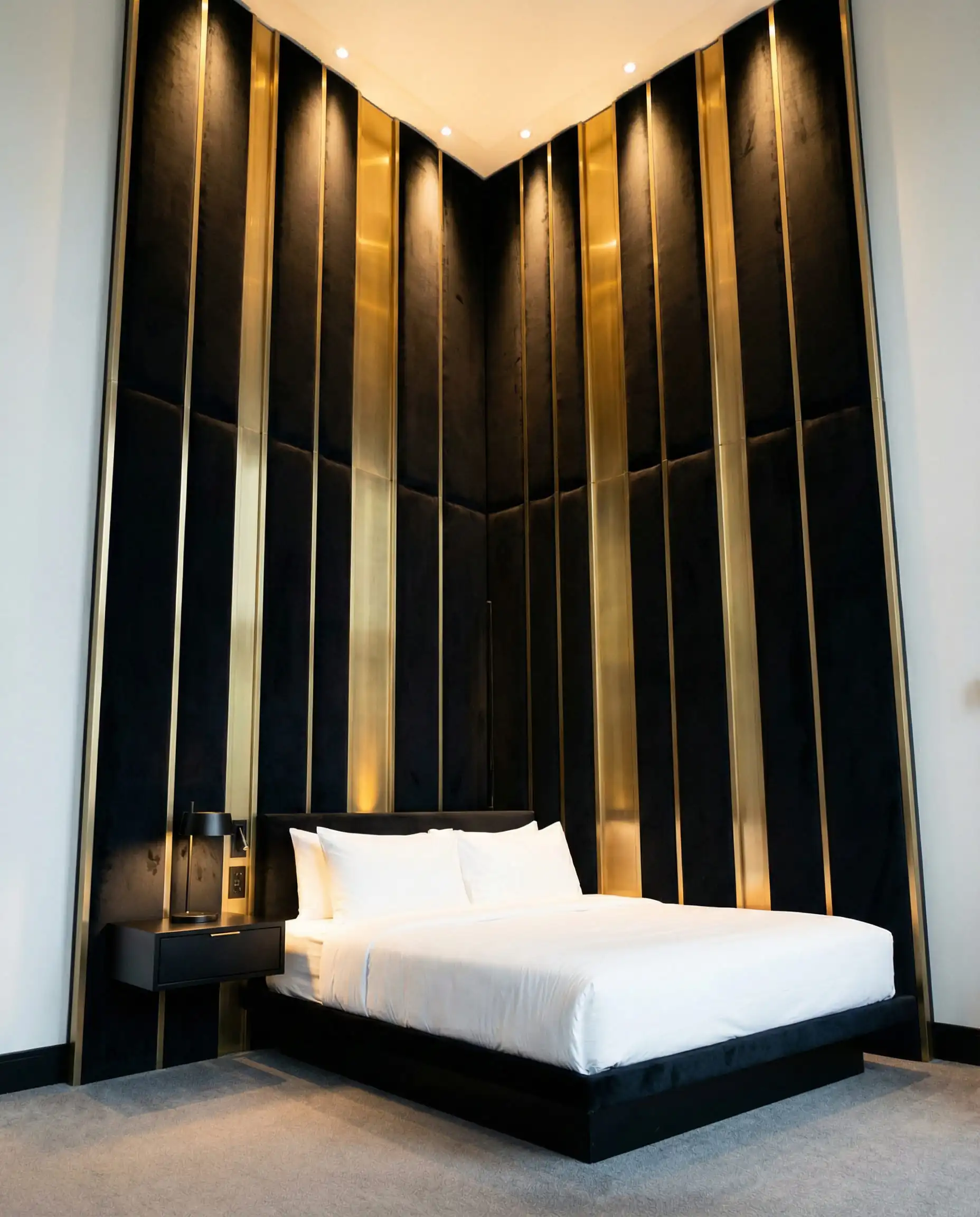 Massive custom black velvet headboard with vertical gold inlay strips.