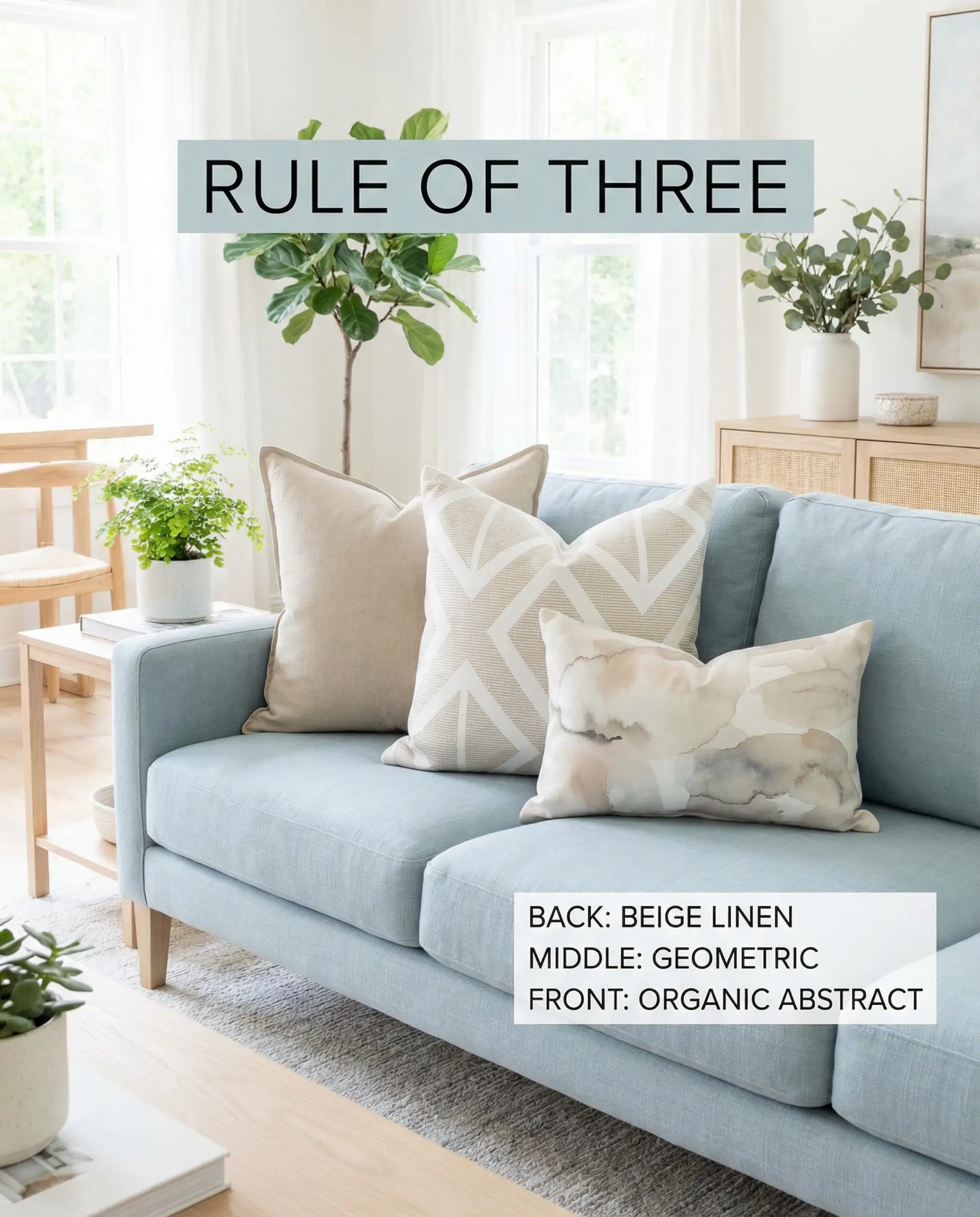 Light blue couch styled with beige solid, geometric white/beige, and abstract watercolor pillows.