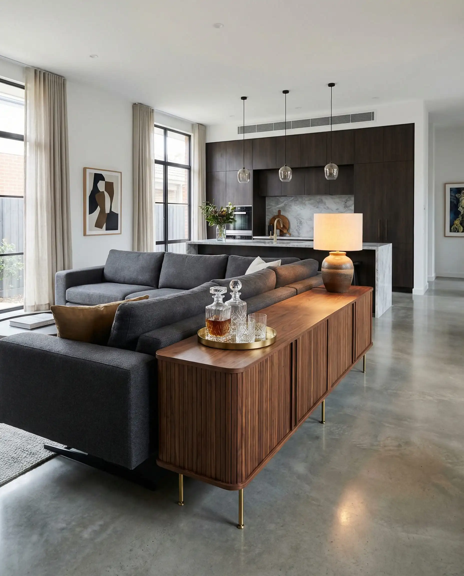 Low walnut sideboard placed behind a sofa to separate kitchen and living room zones.