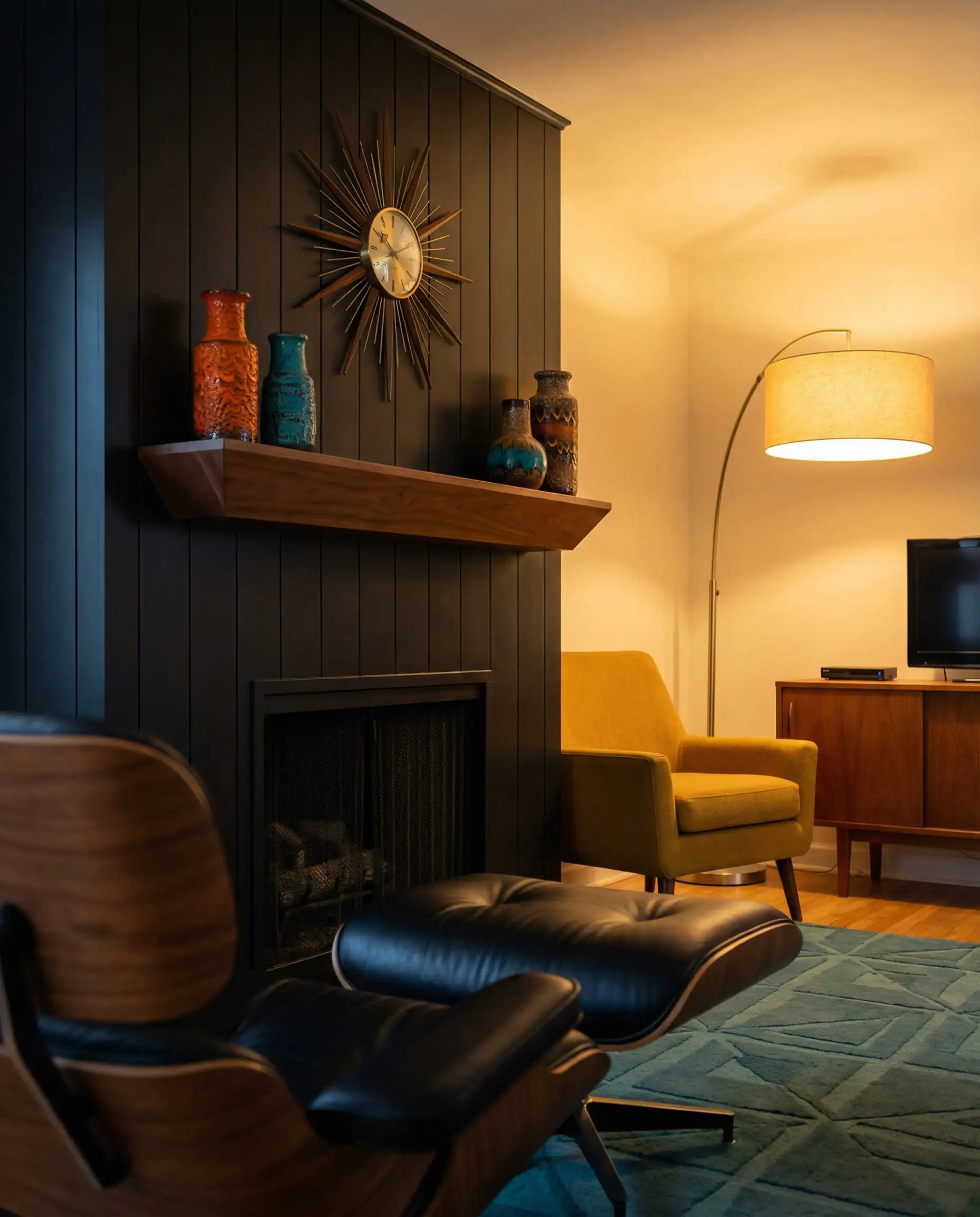 Mid-century modern living room with vertical black shiplap fireplace, walnut mantel, and vintage decor.
