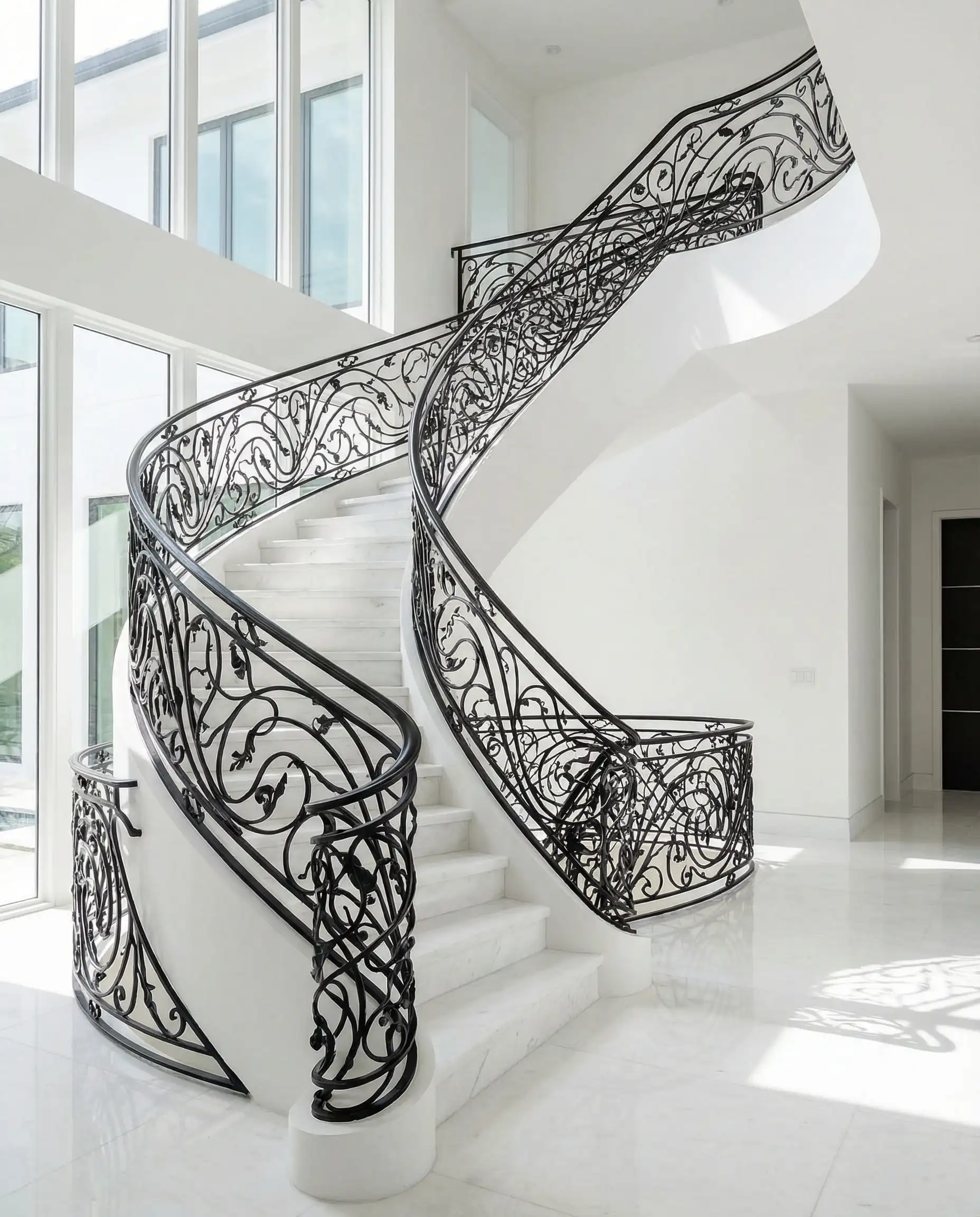 Modern white staircase featuring a custom black wrought-iron railing in a flowing vine design.