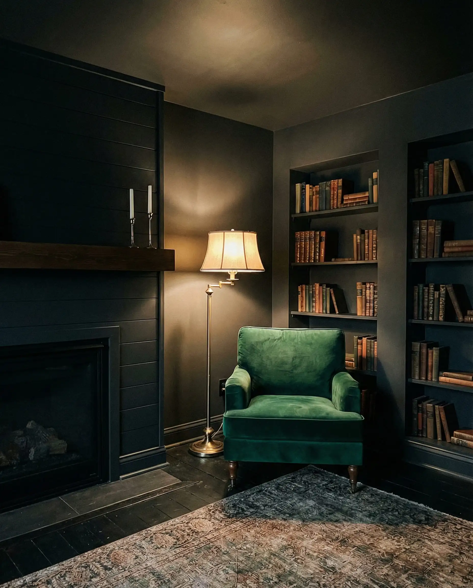 Dark academia style living room with black shiplap fireplace blending into black walls and ceiling.