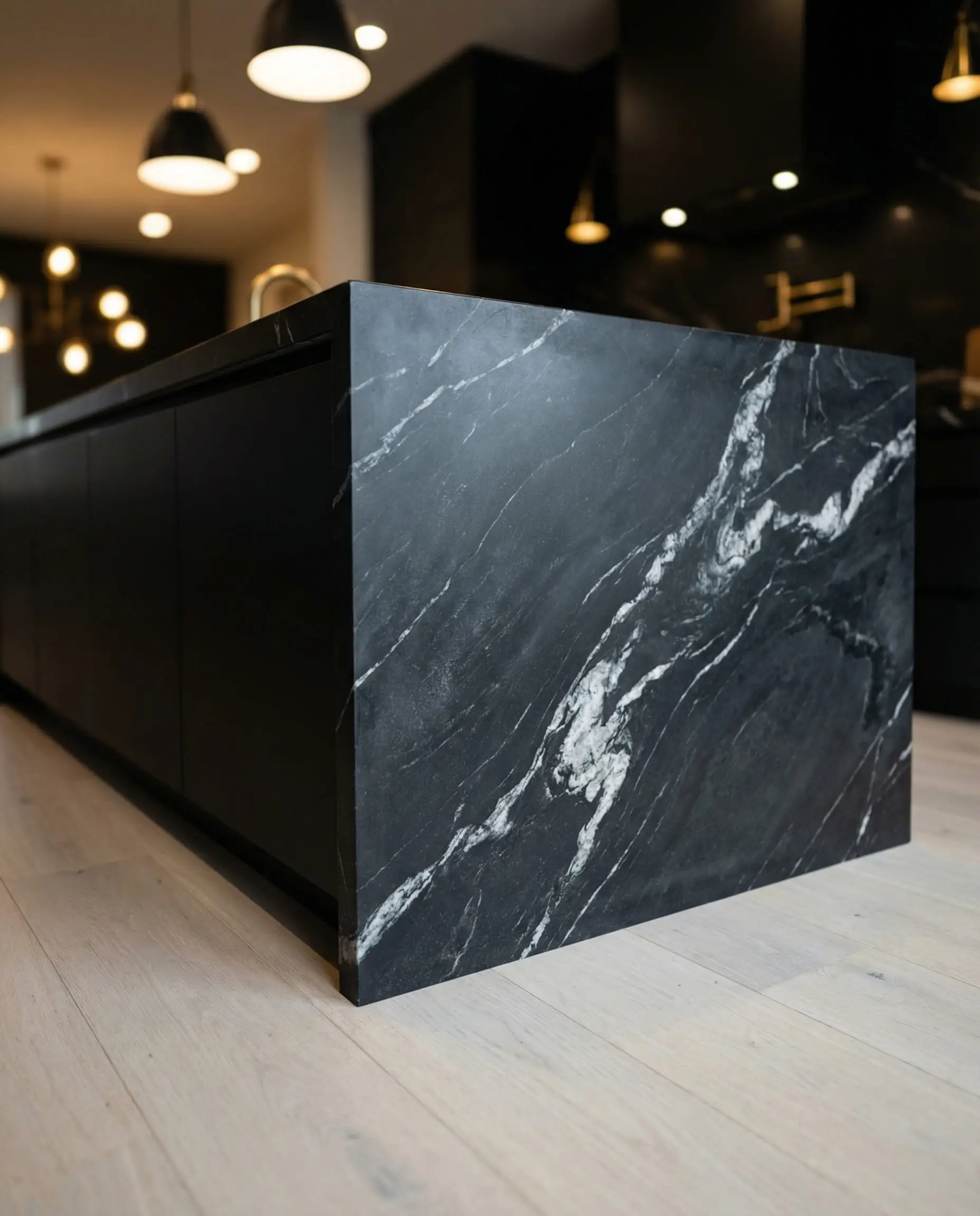 Dramatic Nero Marquina black marble waterfall island with white veining in a modern luxury kitchen.