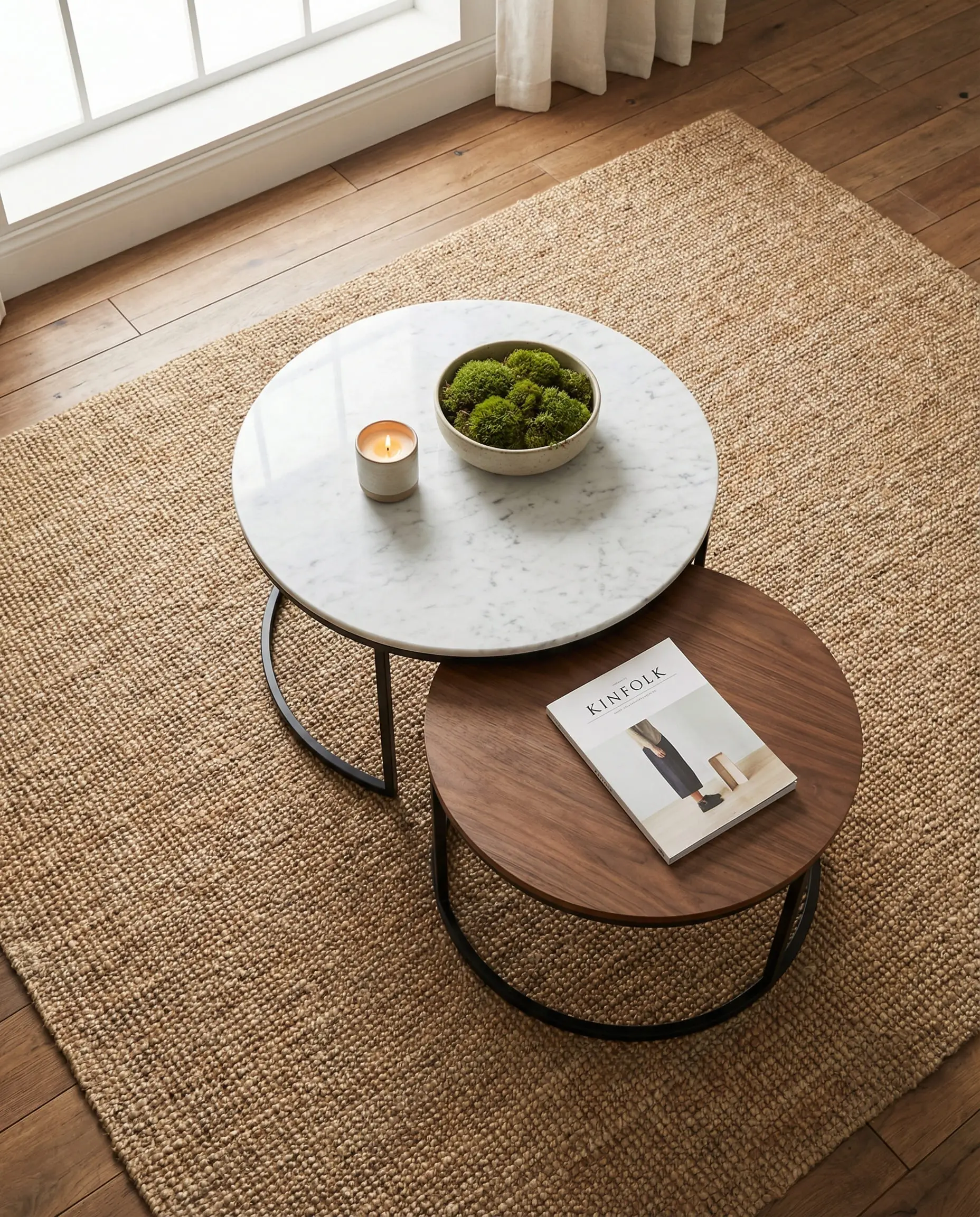Overhead shot of round nesting coffee tables in wood and marble, pulled apart to create more surface area.