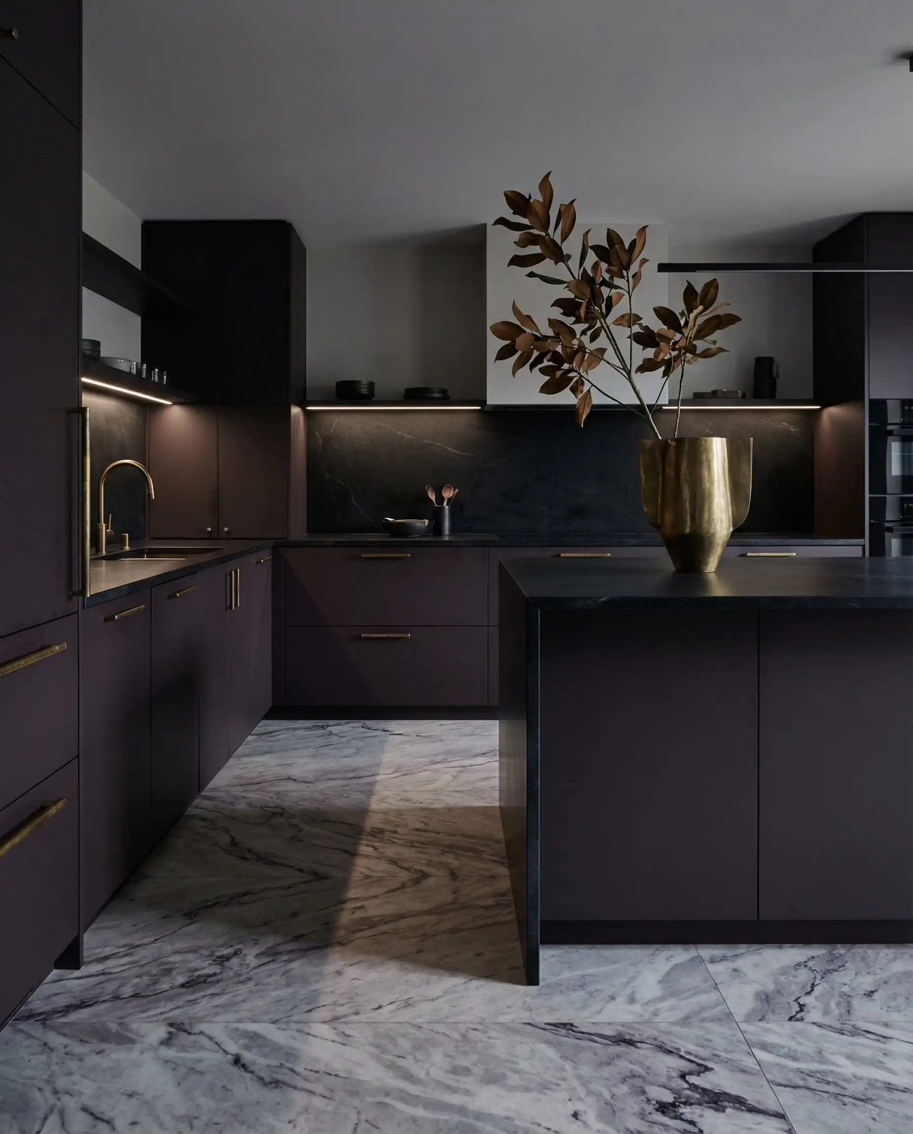 Avant-garde luxury kitchen with matte plum cabinets and heavily veined gray marble flooring.