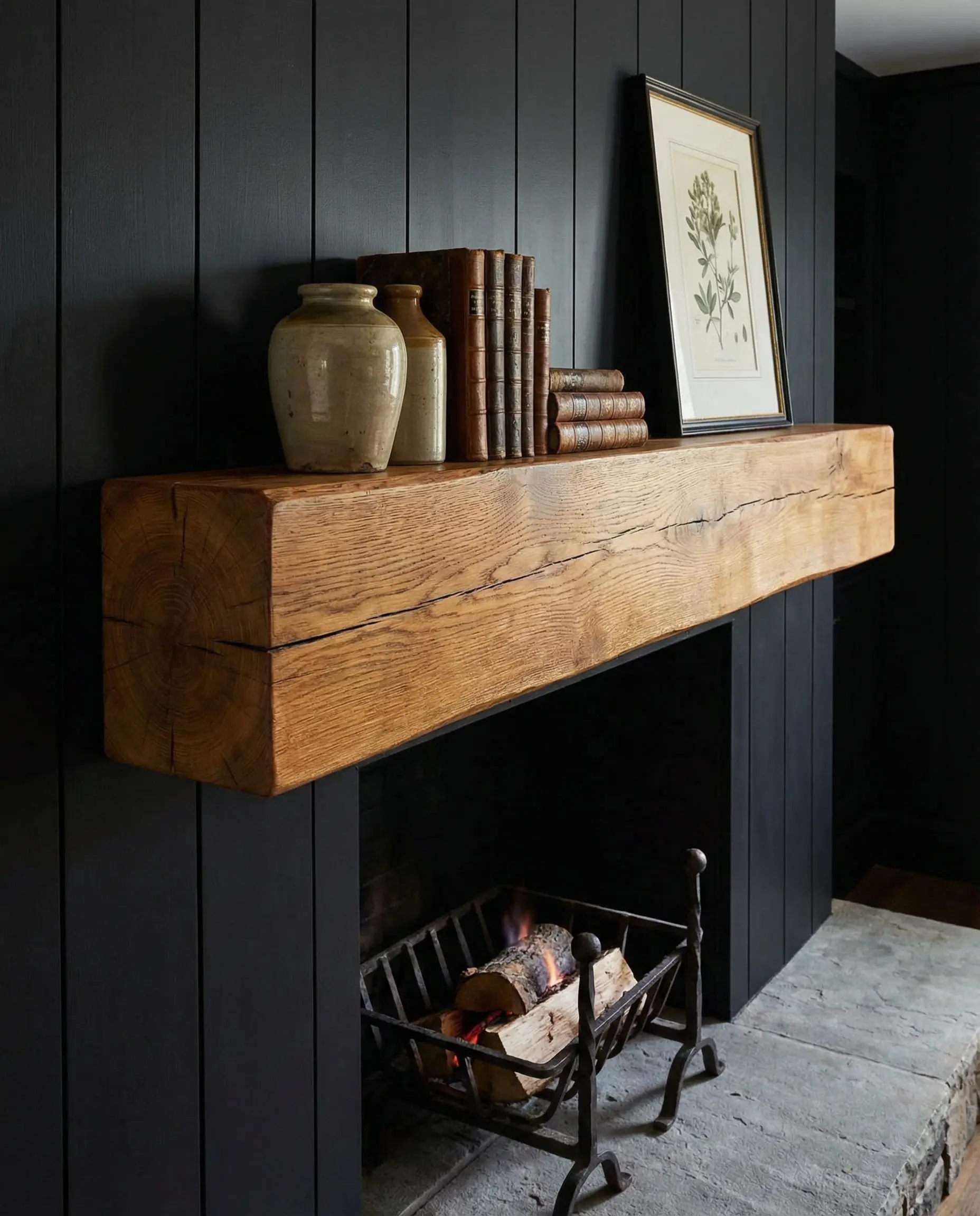 Smooth antique French oak beam mantel on a vertical black shiplap fireplace.