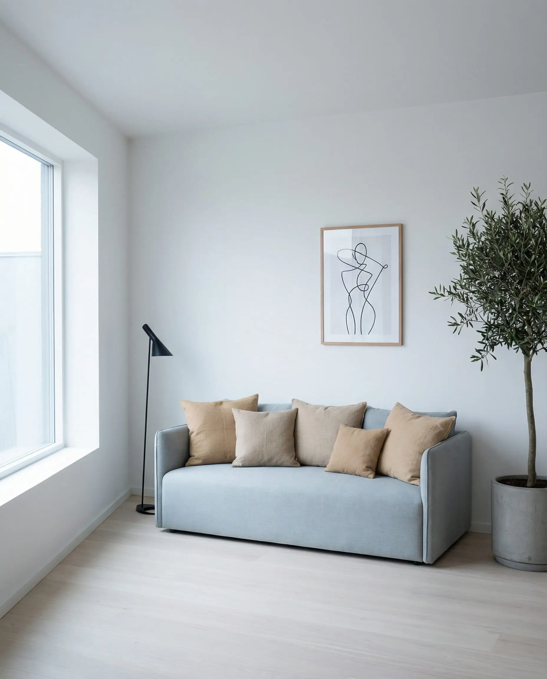 Minimalist Scandinavian blue-grey sofa styled with neutral sand and biscuit-colored canvas pillows.