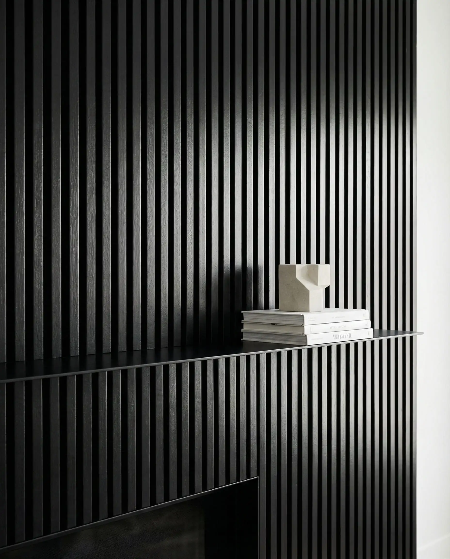 Contemporary fireplace featuring narrow "skinny slat" vertical black wood paneling and a thin metal mantel.