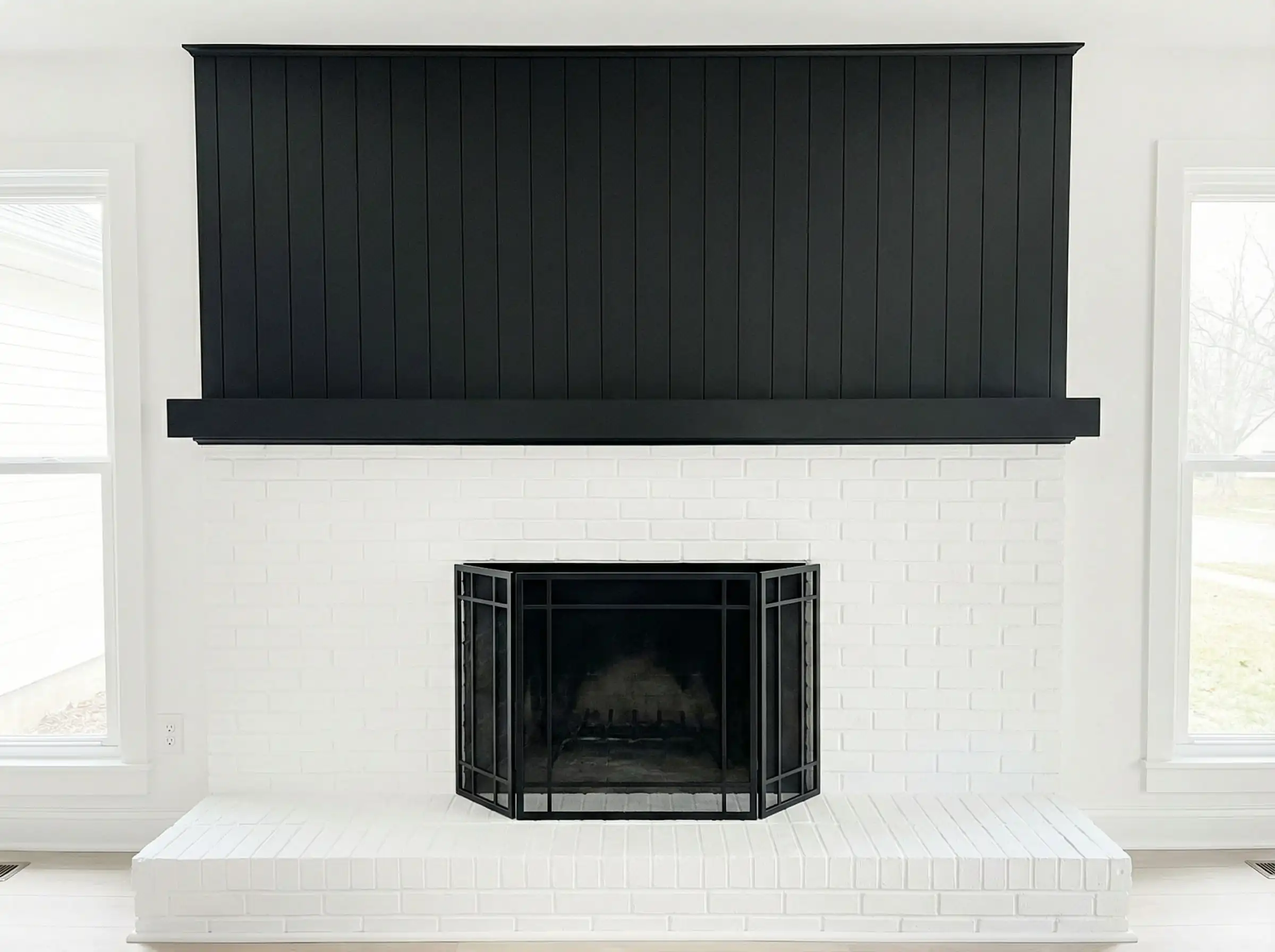 High contrast fireplace with black shiplap top and white brick bottom.