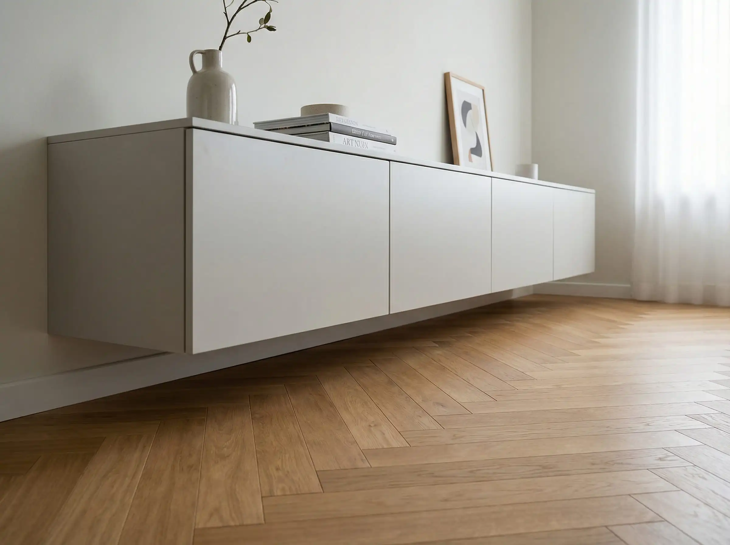 Low angle shot of a floating grey media unit showing herringbone wood floor underneath.
