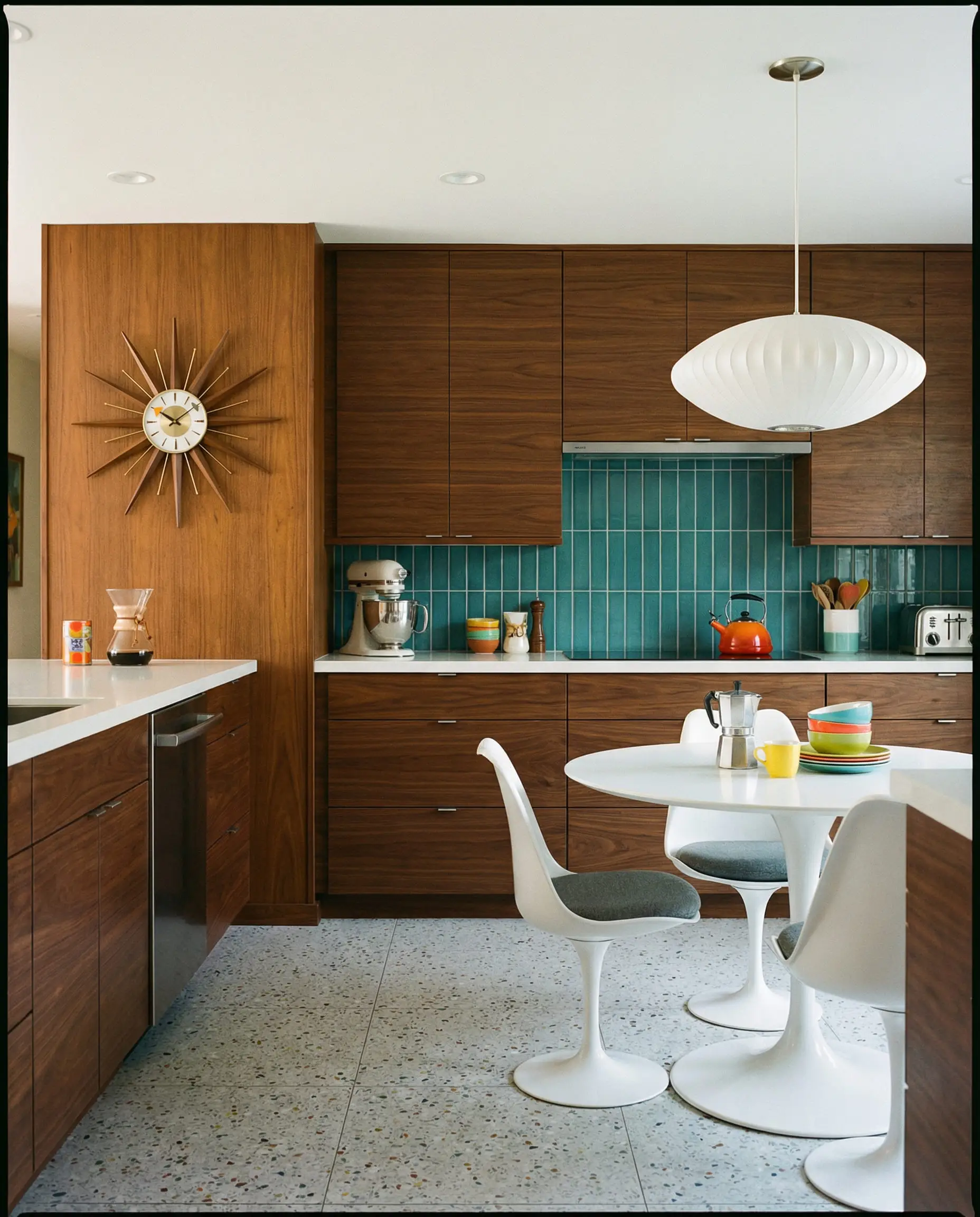 Mid-century modern kitchen with dark walnut flat-panel cabinets and light gray terrazzo flooring.