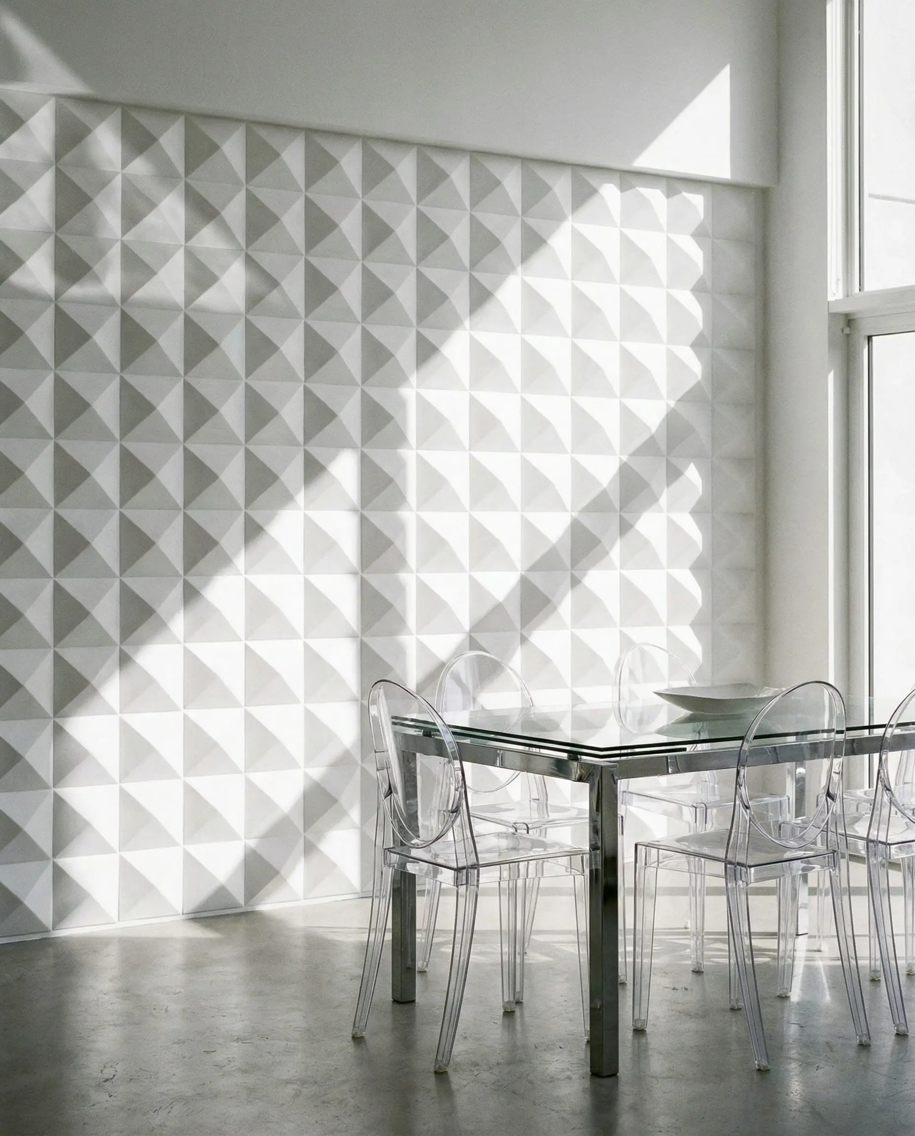 Contemporary dining room feature wall covered in white 3D geometric panels with a diamond pattern, highlighting shadow and light.