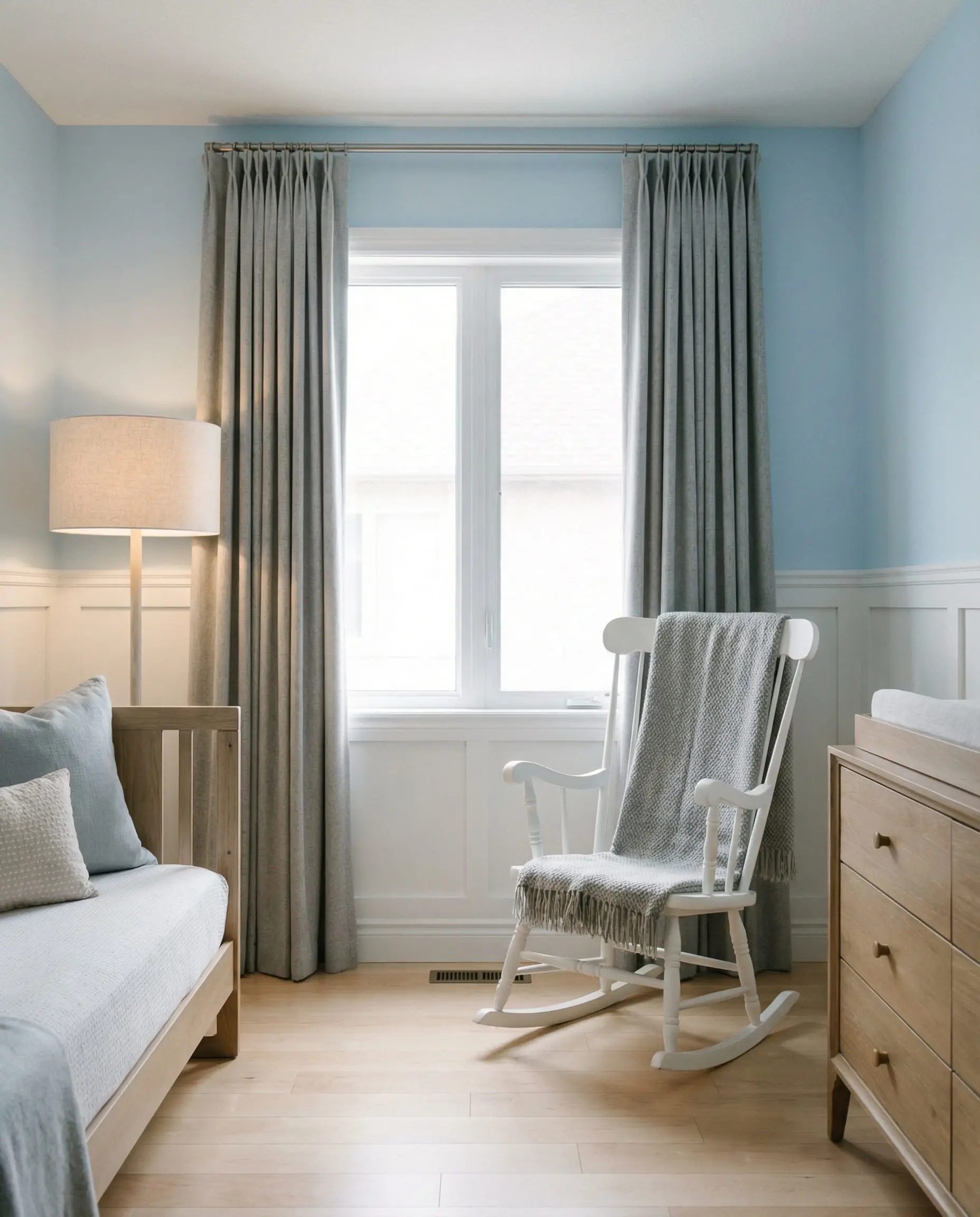 Serene nursery with baby blue walls and soft dove gray cashmere curtains.