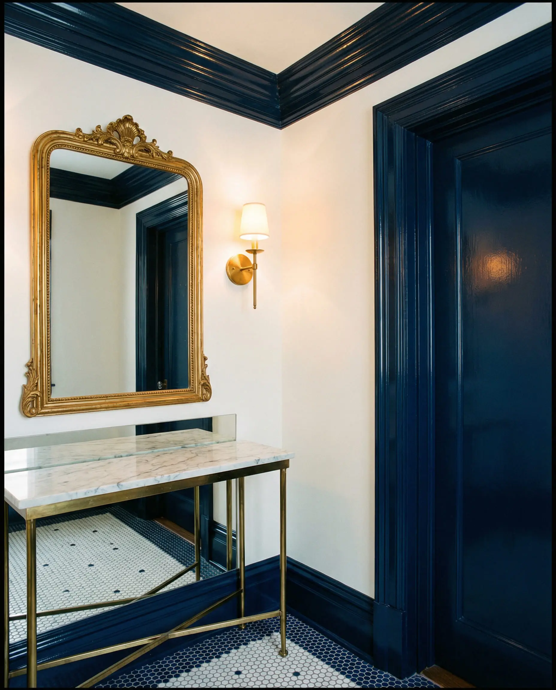 Powder room featuring deep blue Benjamin Moore Hale Navy trim on crown molding and door frames.