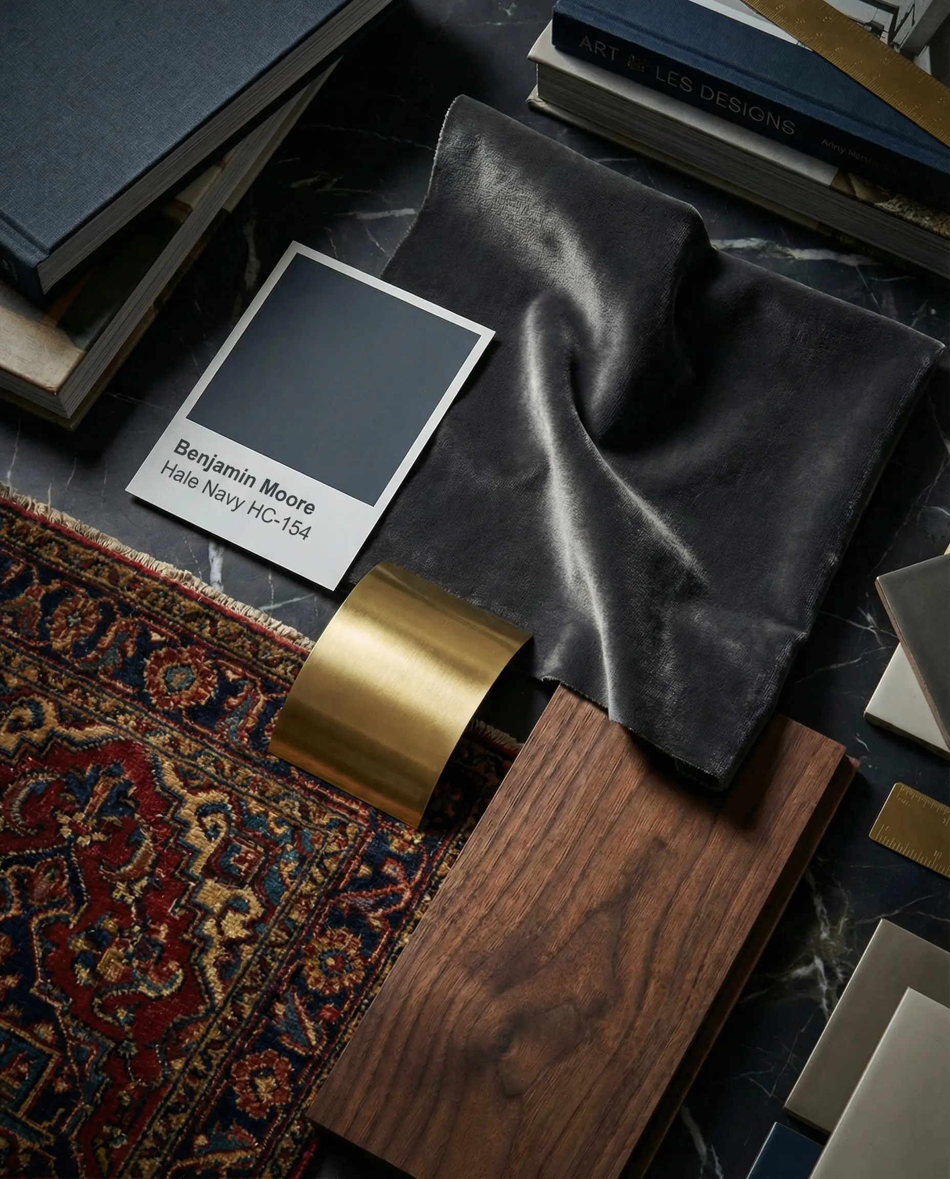 Moody luxury interior design mood board showing Benjamin Moore Hale Navy paint, charcoal velvet fabric, and brushed brass accents.