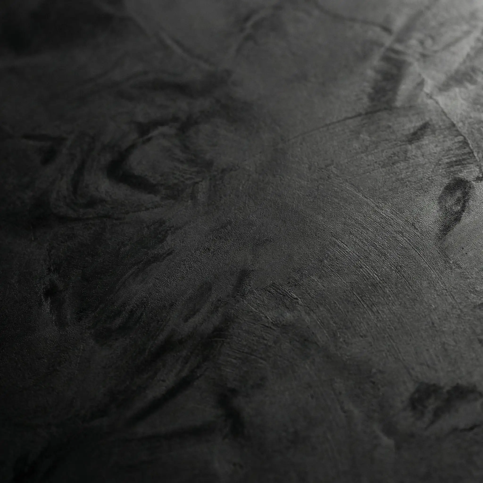 Directional studio light catches the subtle highs and lows of deep black roman clay colors, revealing a honed slate texture with subtle marbling.