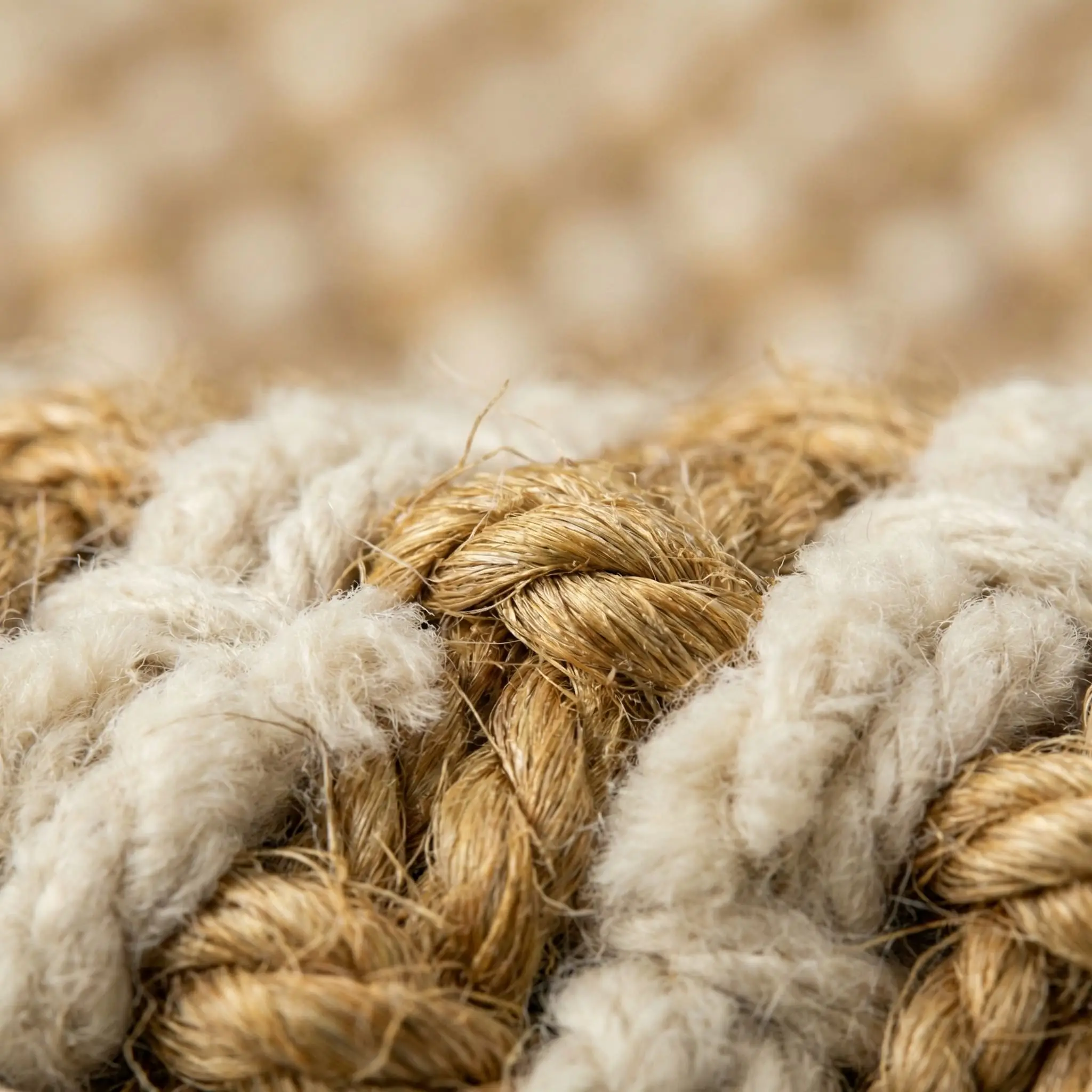 Macro texture showing thick, organic natural jute twisted seamlessly with soft cream chenille yarns for a scratch-free finish.
