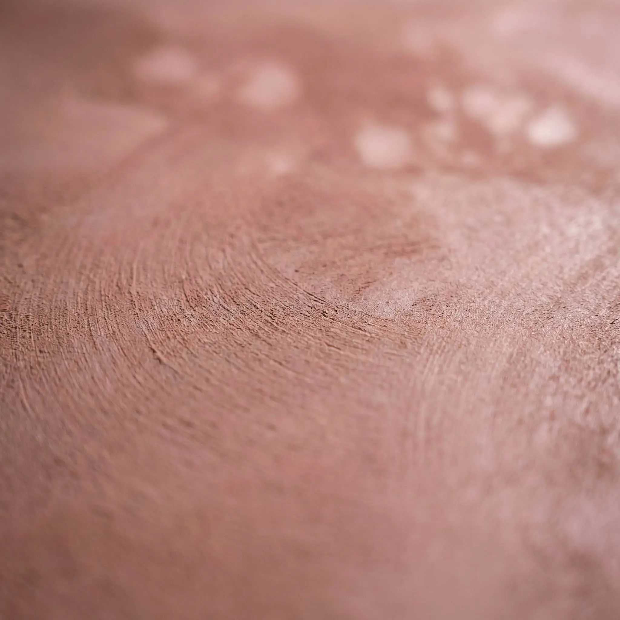 A macro close-up of dusty rose roman clay colors highlights a smooth, suede-like burnished finish with warm pinkish-brown undertones mimicking unbaked earth.