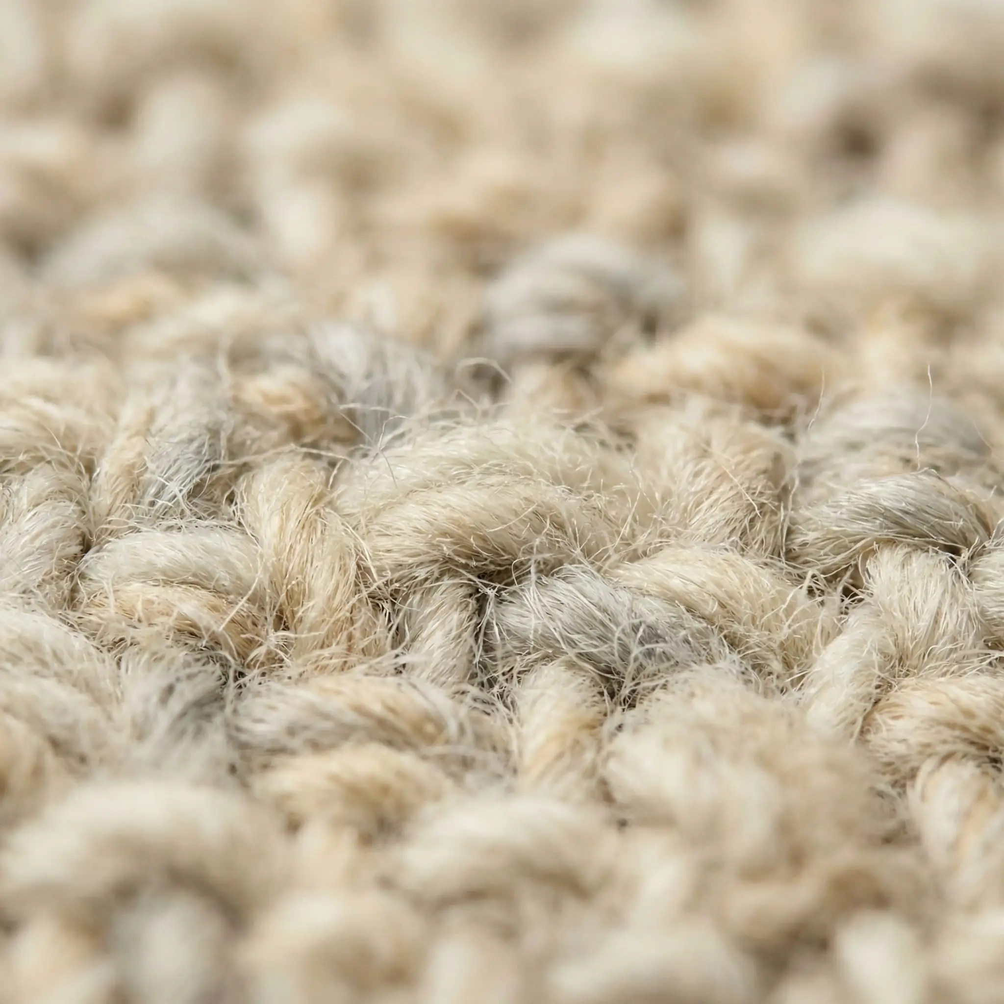 Close-up of a densely woven performance wool rug featuring optical camouflage shades of cream, beige, and light gray.
