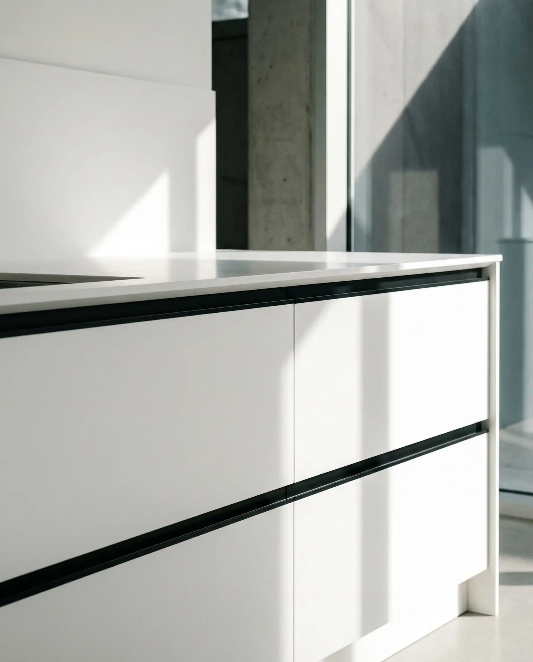Sleek Scandinavian white flat-panel kitchen featuring a recessed black channel rail (Gola profile) instead of protruding handles.
