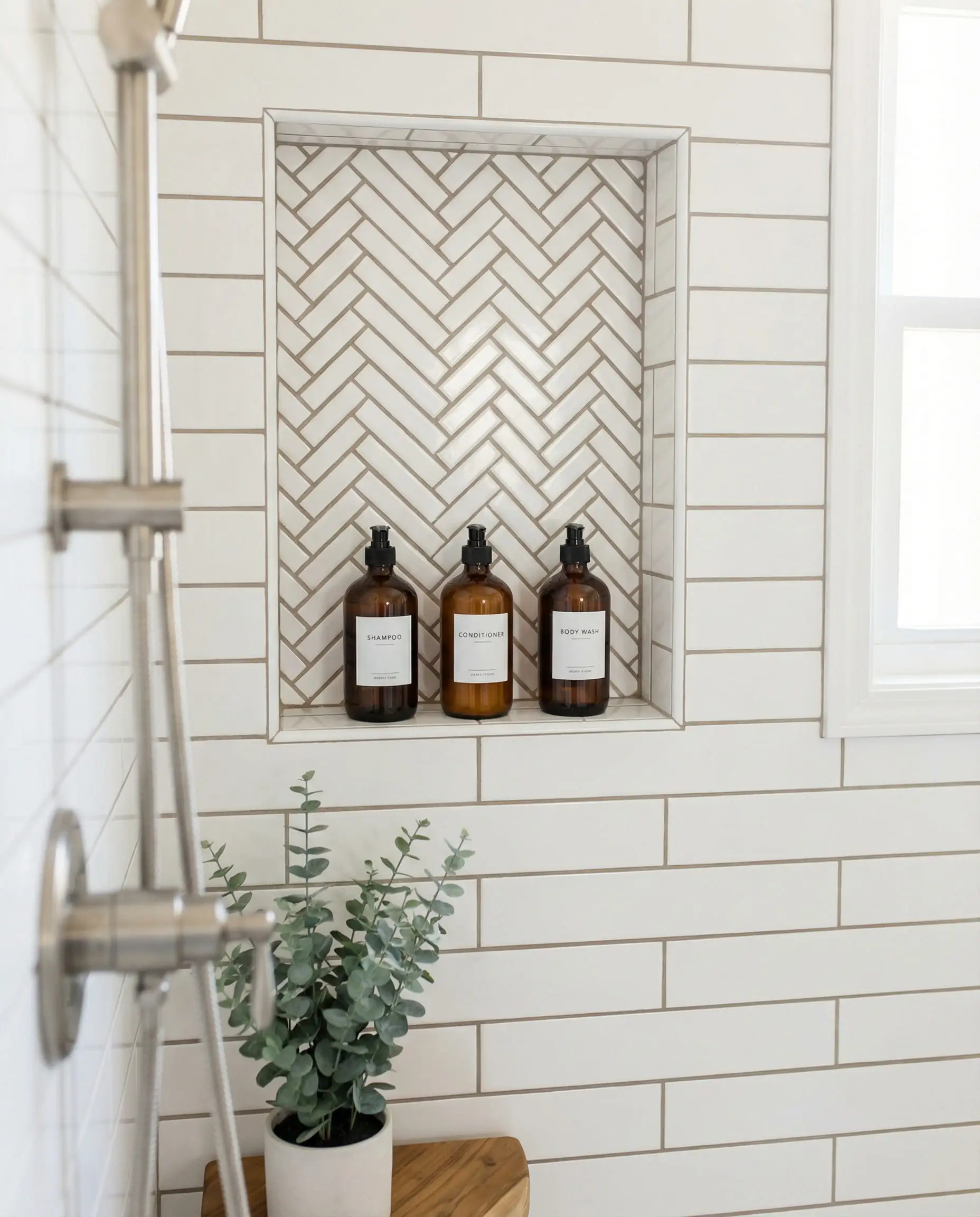 Shower niche featuring inexpensive subway tile laid in a herringbone pattern.