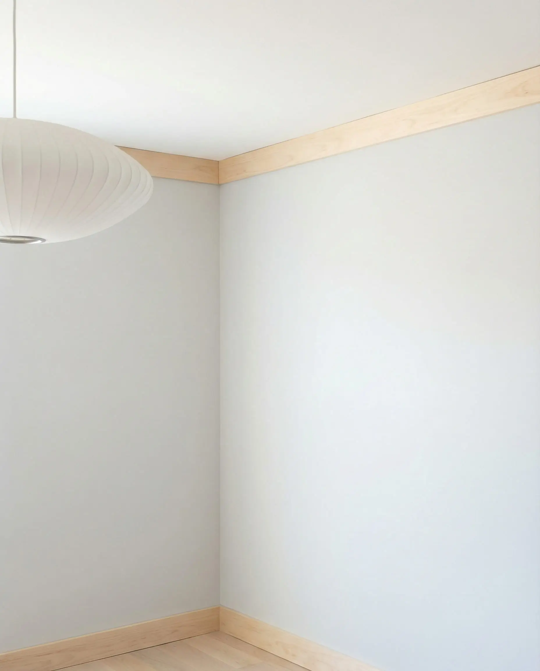 Bright Scandinavian living room corner featuring simple flat stock wood molding for a clean, minimalist wall-to-ceiling transition.