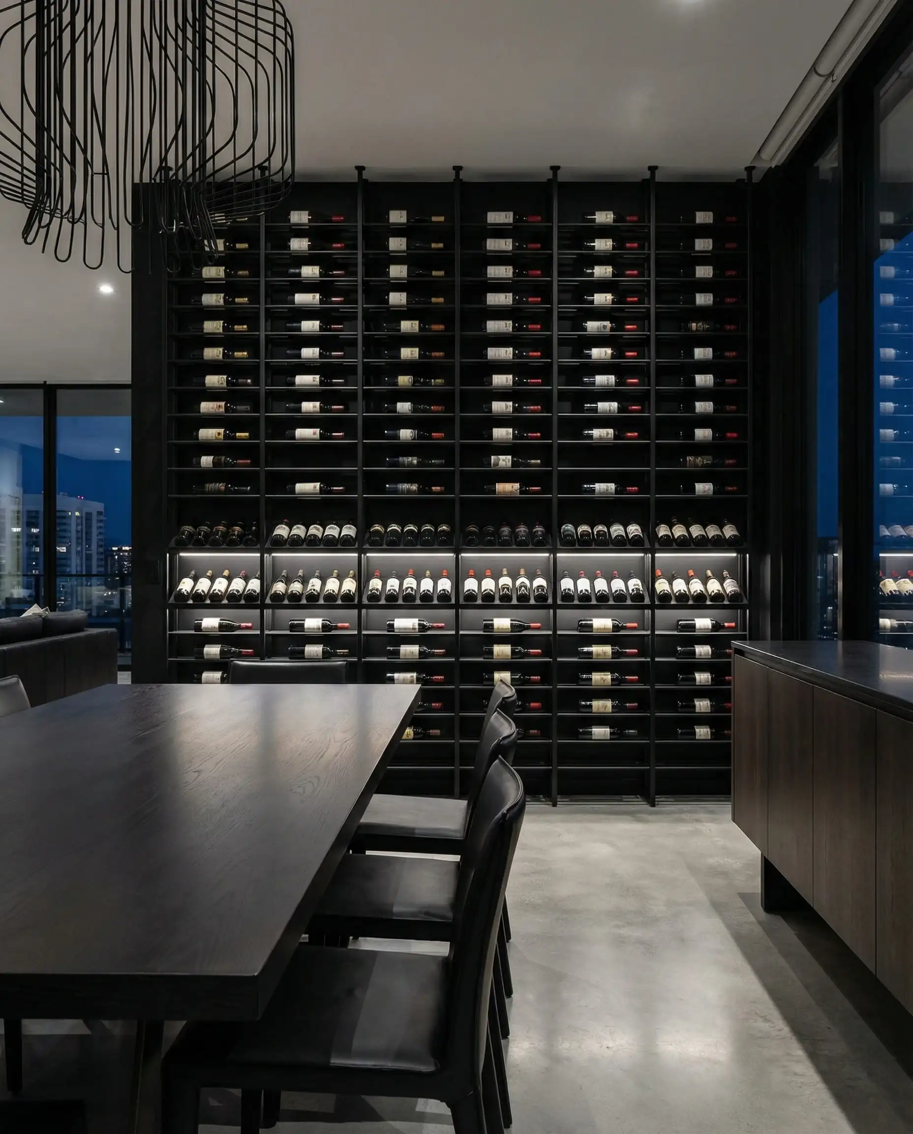 Sleek dining room accent wall with floor-to-ceiling black metal wine racks and LED lighting.