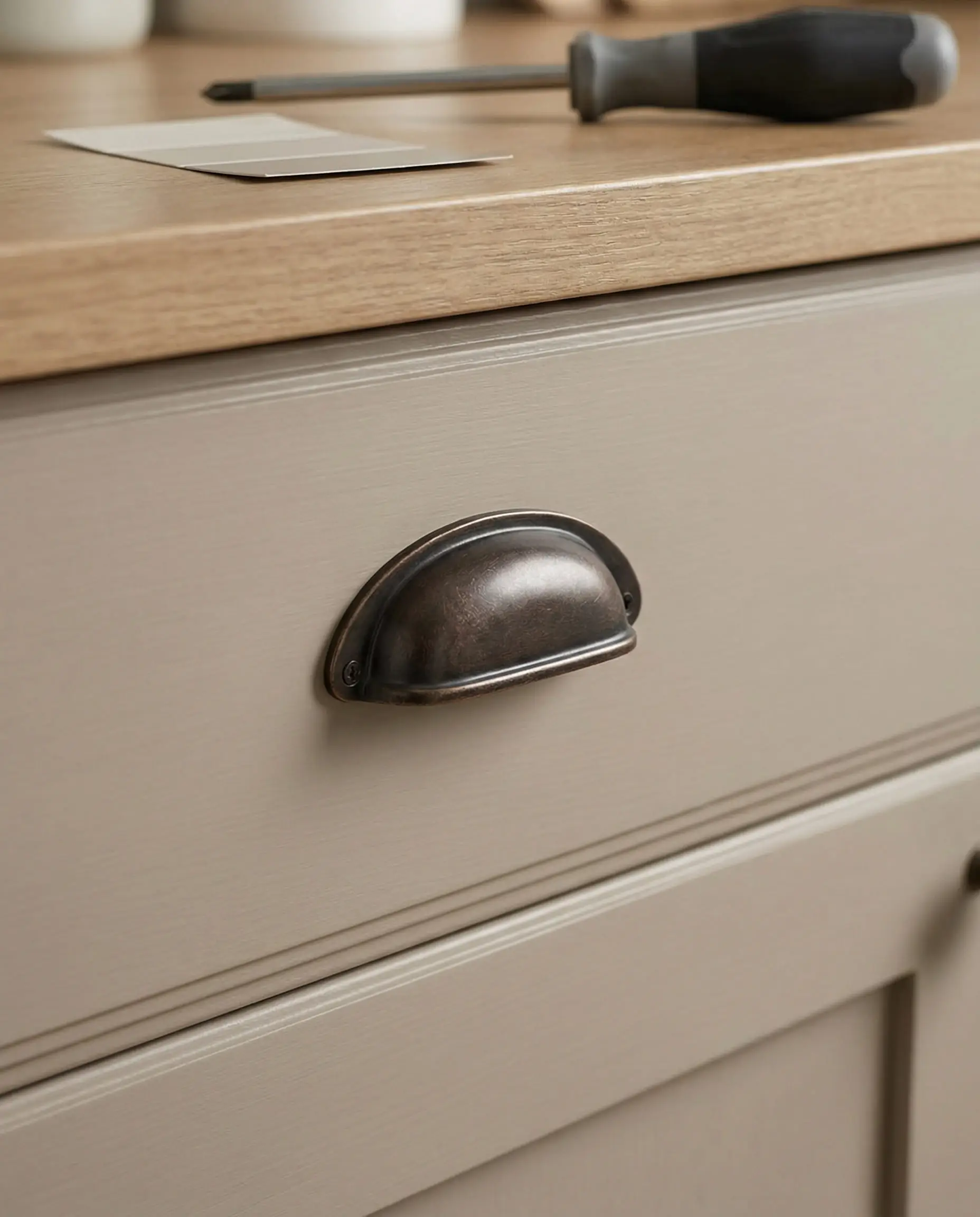 Close up of a kitchen drawer with a new vintage-style oil rubbed bronze bin pull.