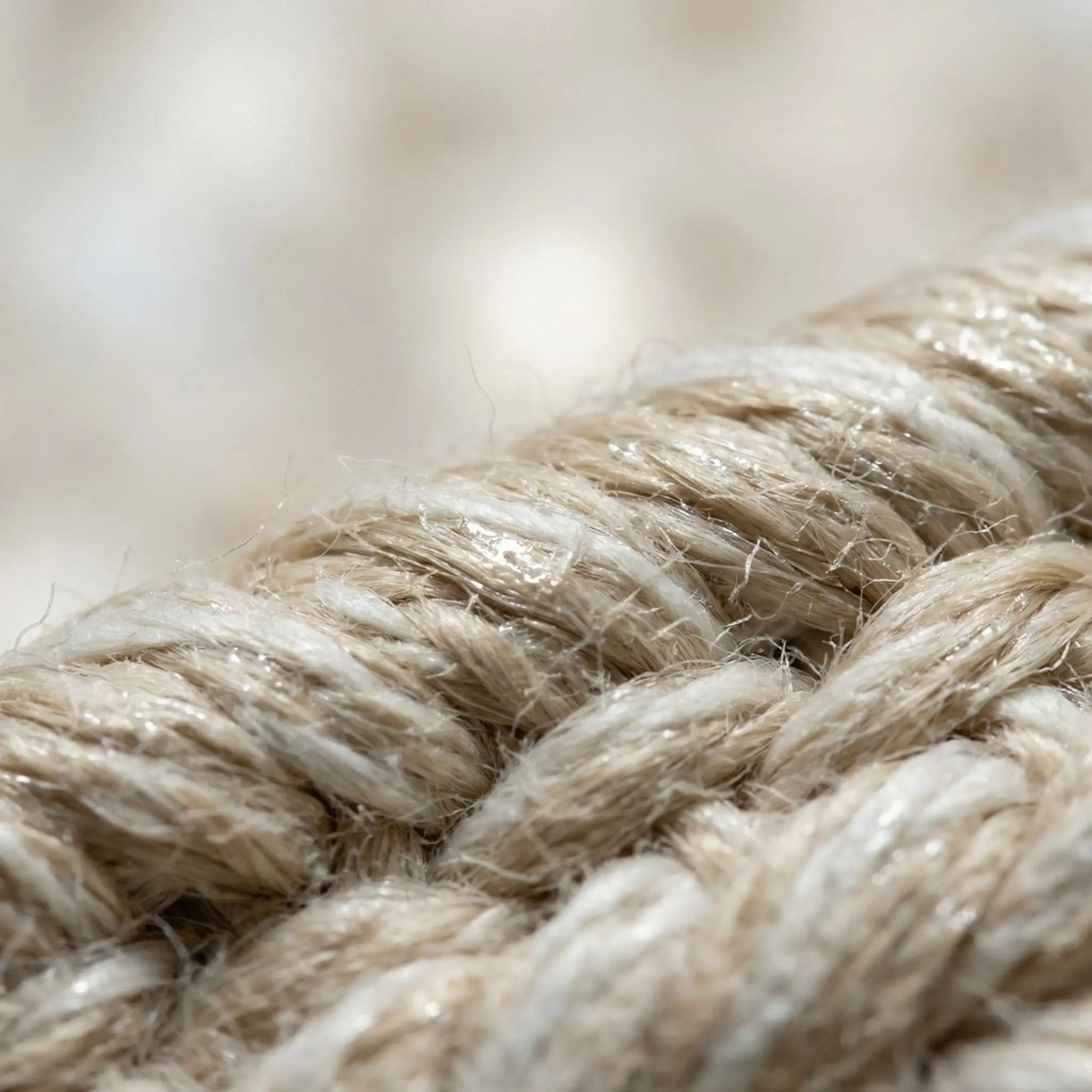 Extreme close-up of breathable raw cotton fibers in a lightweight flat weave, protected by an invisible stain-repellent finish.