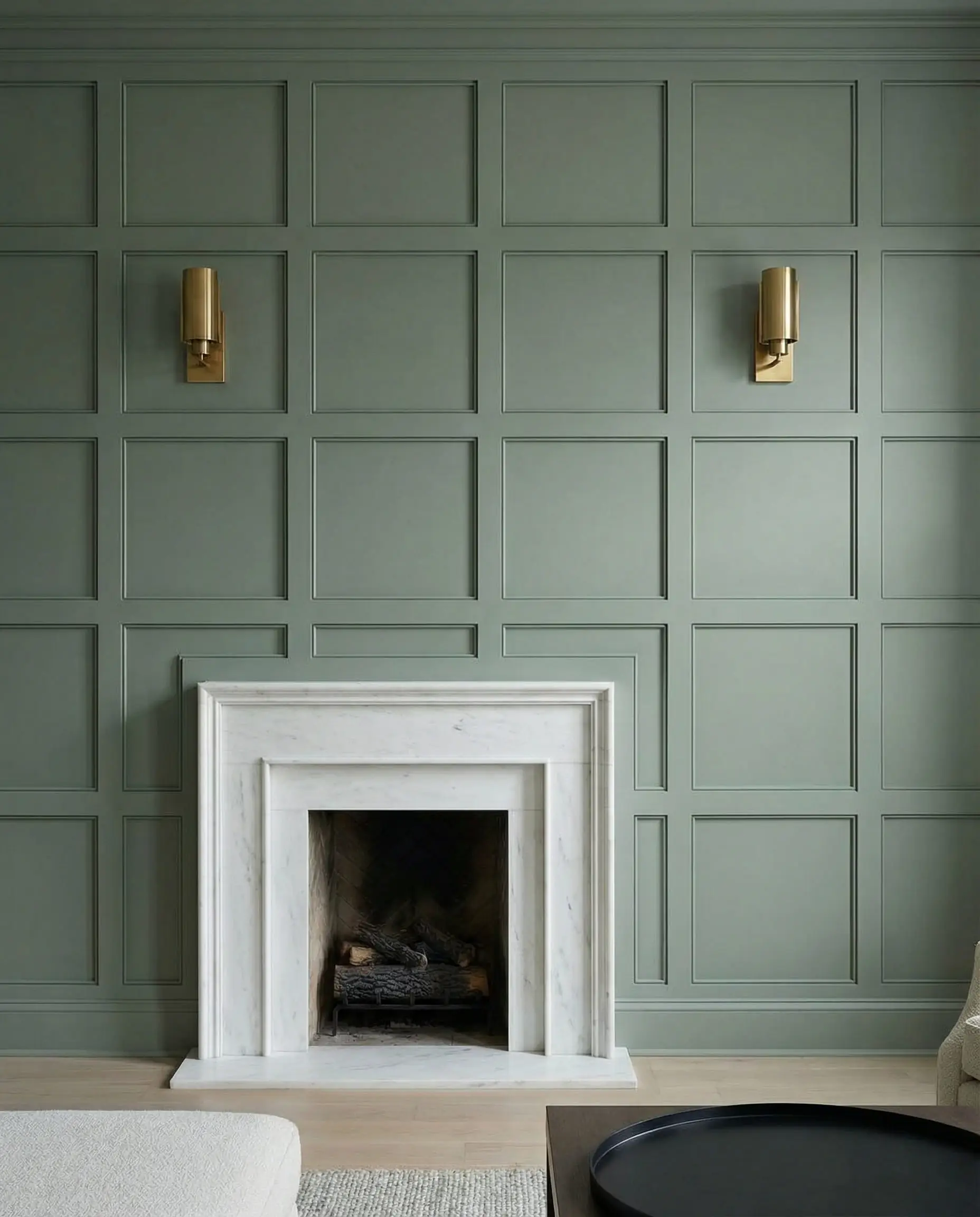 A transitional fireplace wall featuring geometric grid board-and-batten millwork painted in a soft sage green.