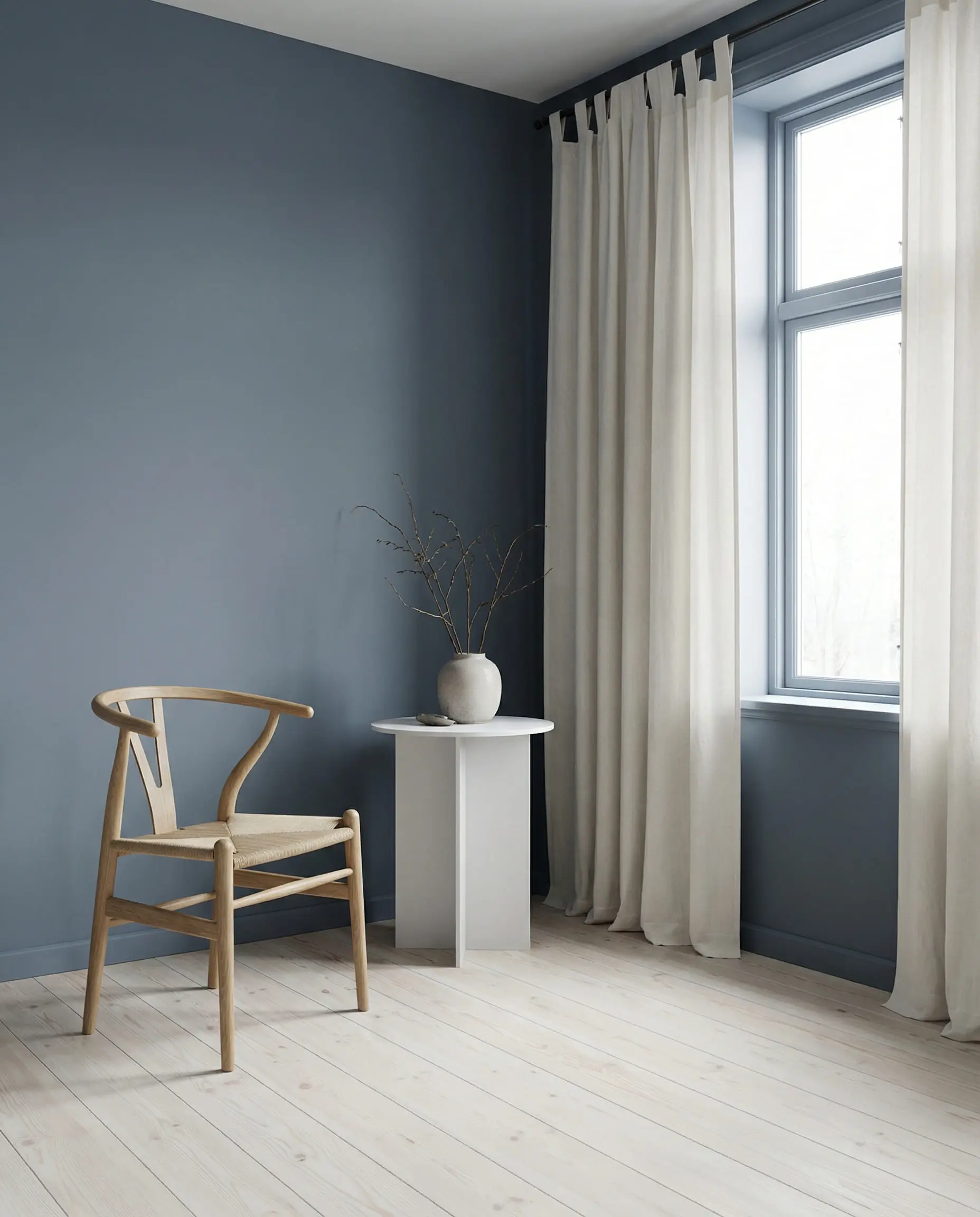 Scandi style living room with slate blue walls and off-white cotton curtains.