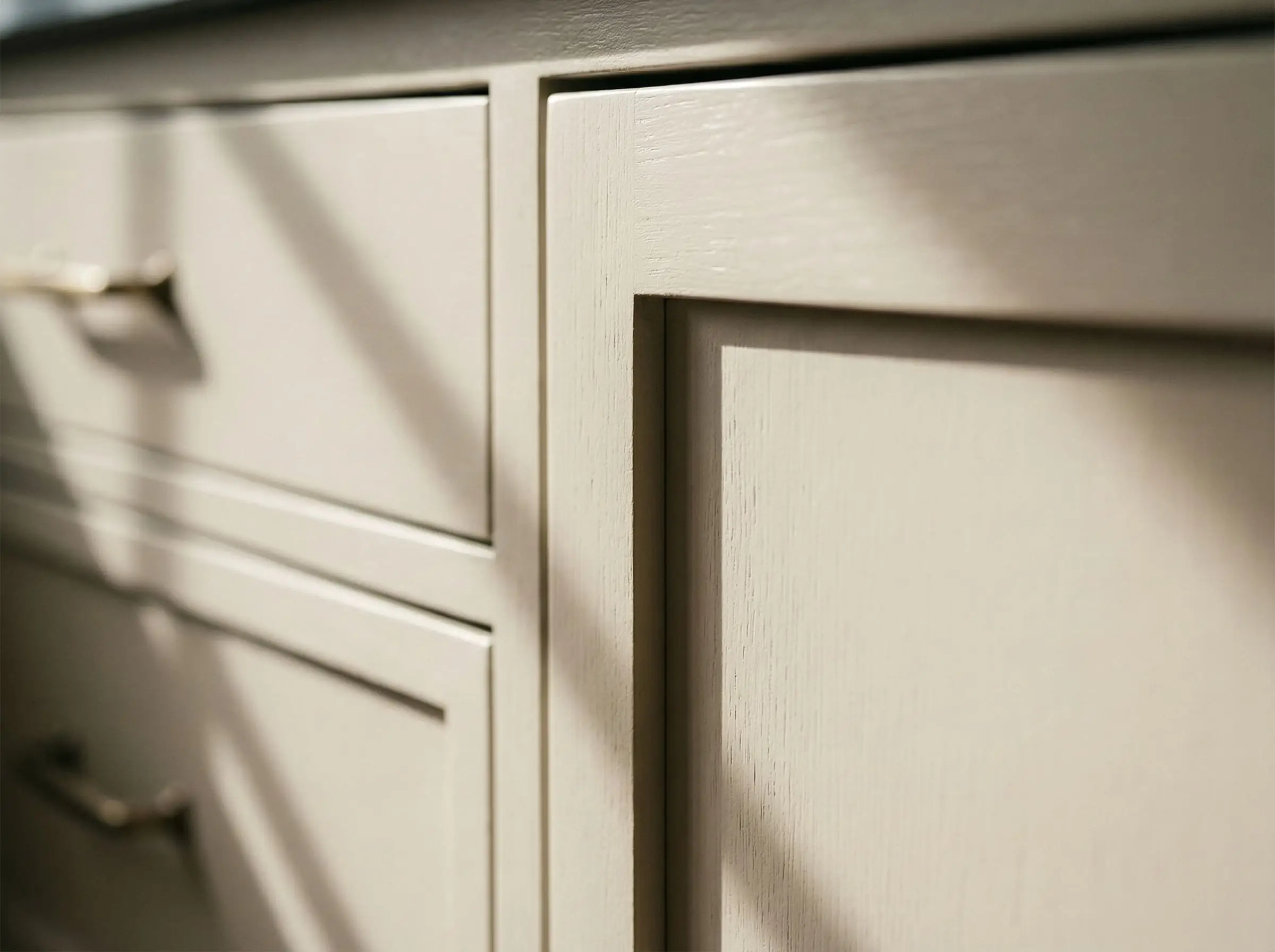 A close-up reveals the crisp shadow line and painted wood grain of a half-inch Slim Shaker cabinet stile.