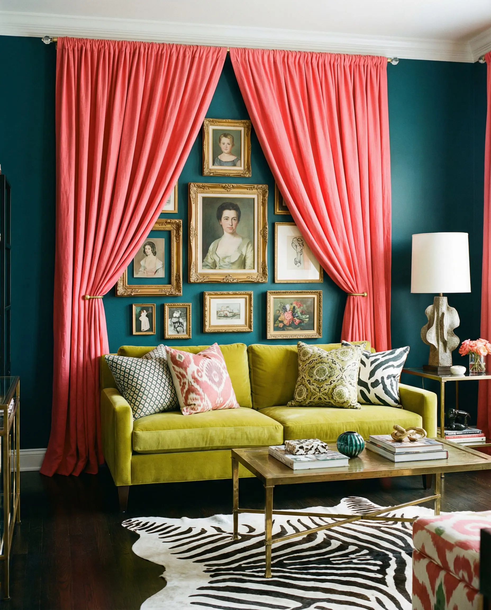 Eclectic living room with teal walls and bold coral pink linen curtains.