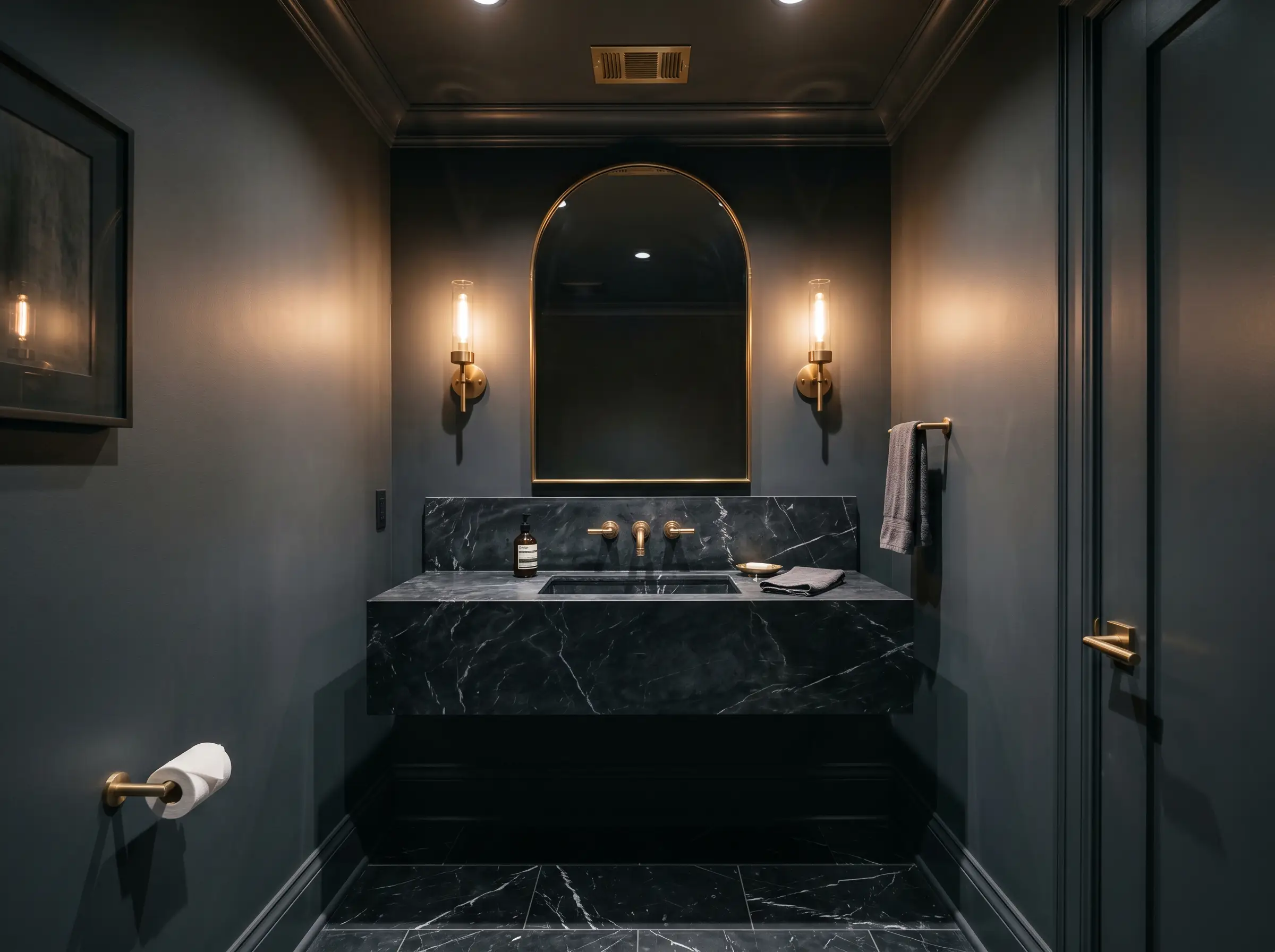 A jewel-box powder room completely wrapped in Benjamin Moore Deep Space (Hex #52565A) showcases a honed Nero Marquina marble floating sink and unlacquered brass fixtures.