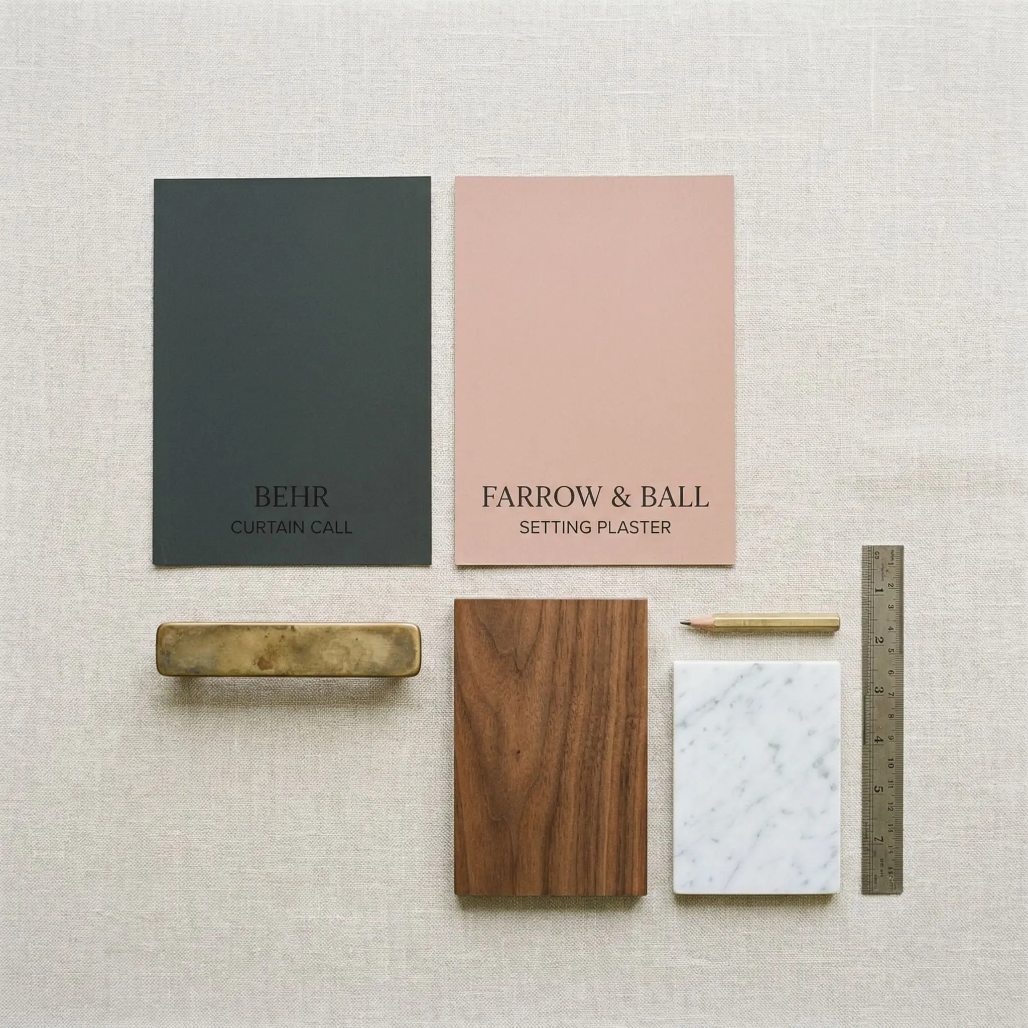 An architectural flat-lay features matte walnut wood, honed Carrara marble, and unlacquered brass hardware alongside a painted color card of Behr Curtain Call.