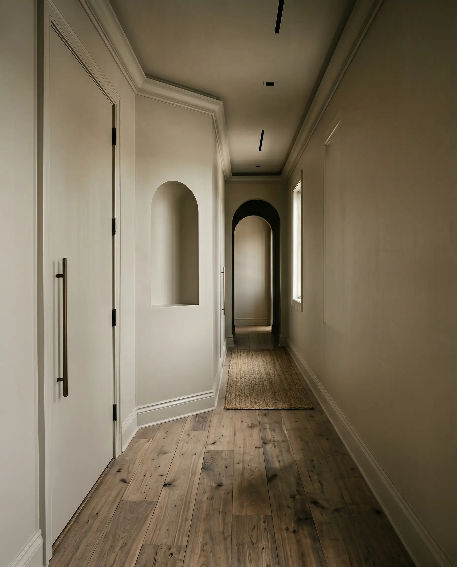 An entire entryway, including walls, trim, doors, and ceiling, is color-drenched in Farrow & Ball Drop Cloth (Hex #c5bdac) above bleached walnut flooring.