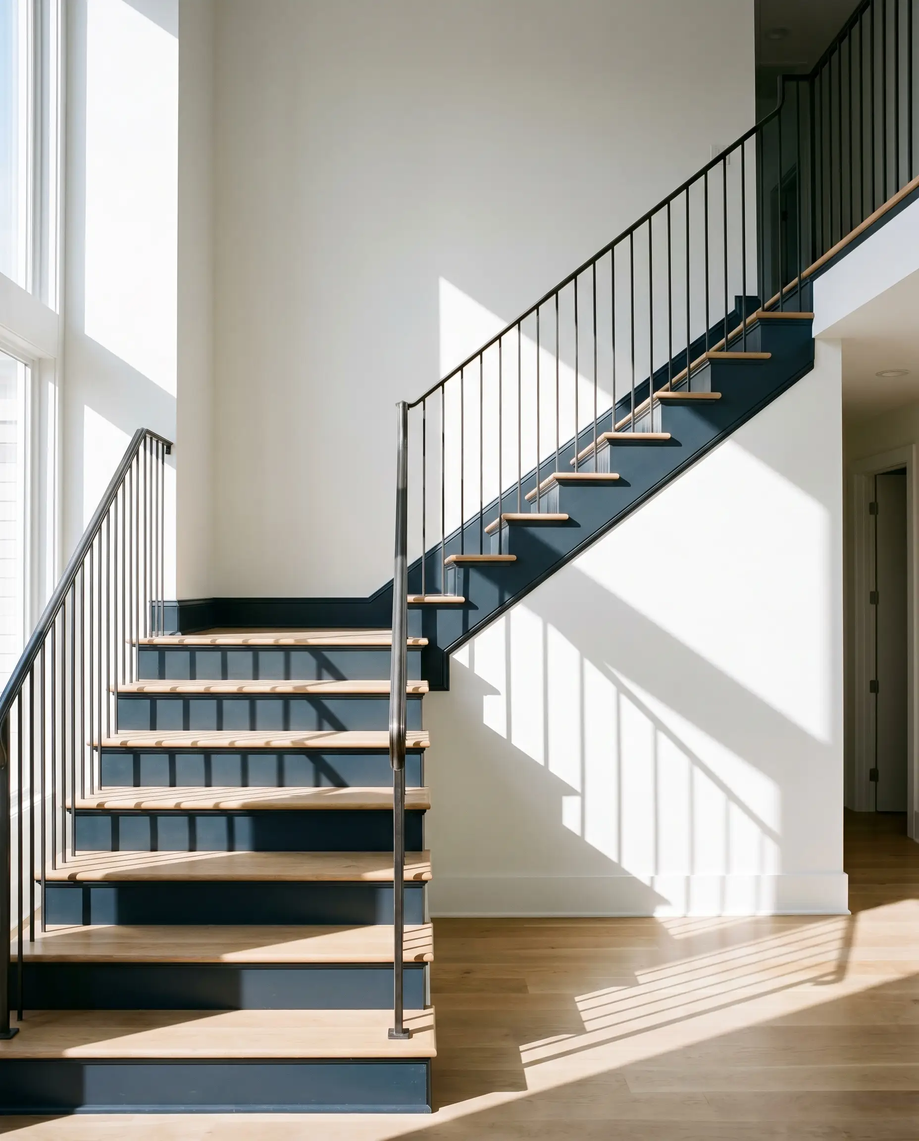 A high-contrast traditional staircase pairs natural white oak treads with risers and stringers painted in Benjamin Moore Polo Blue.
