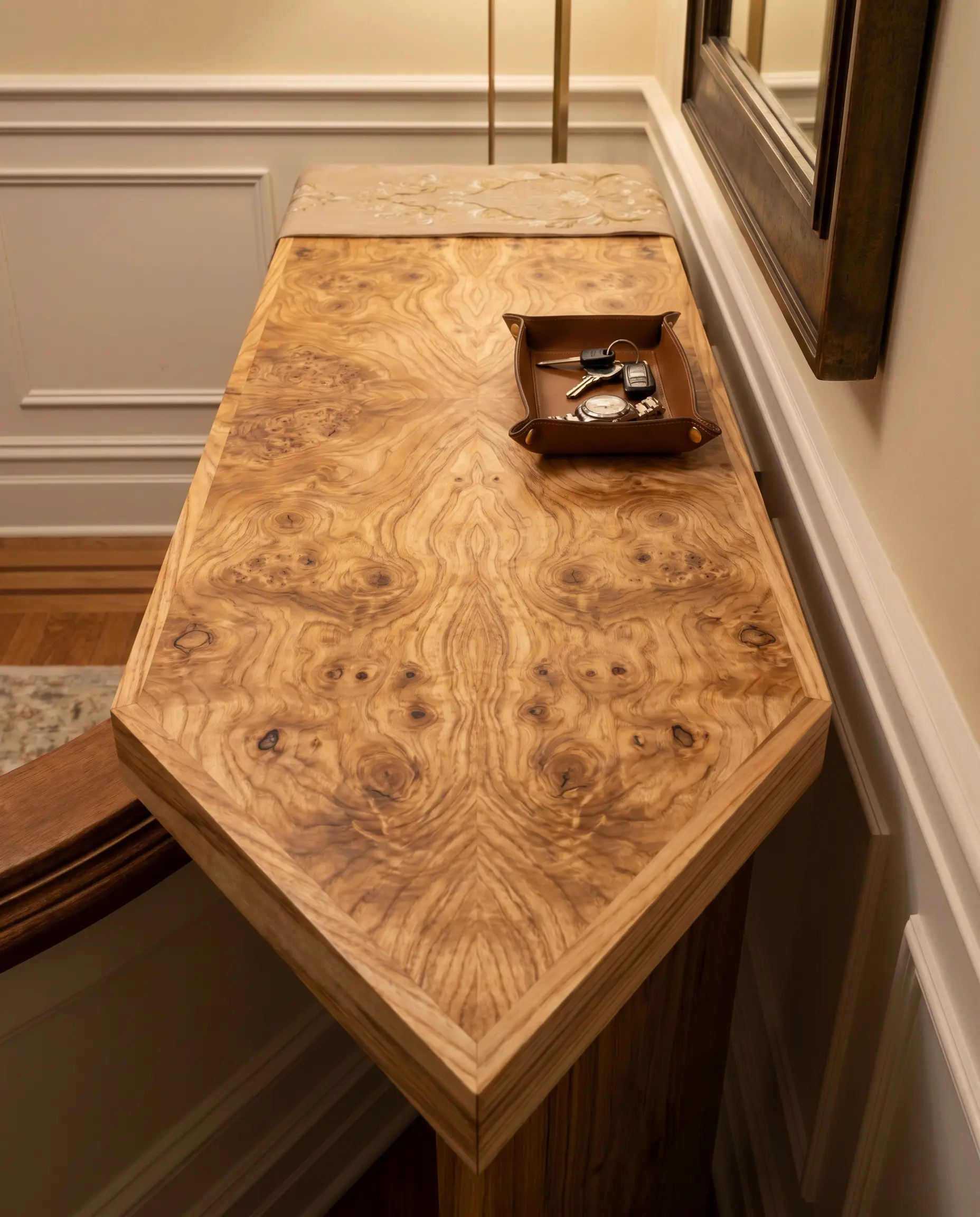 A premium Olive Ash burl console table showcases authentic book-matched veneer with thick edge banding, styled with a luxury catch-all tray.