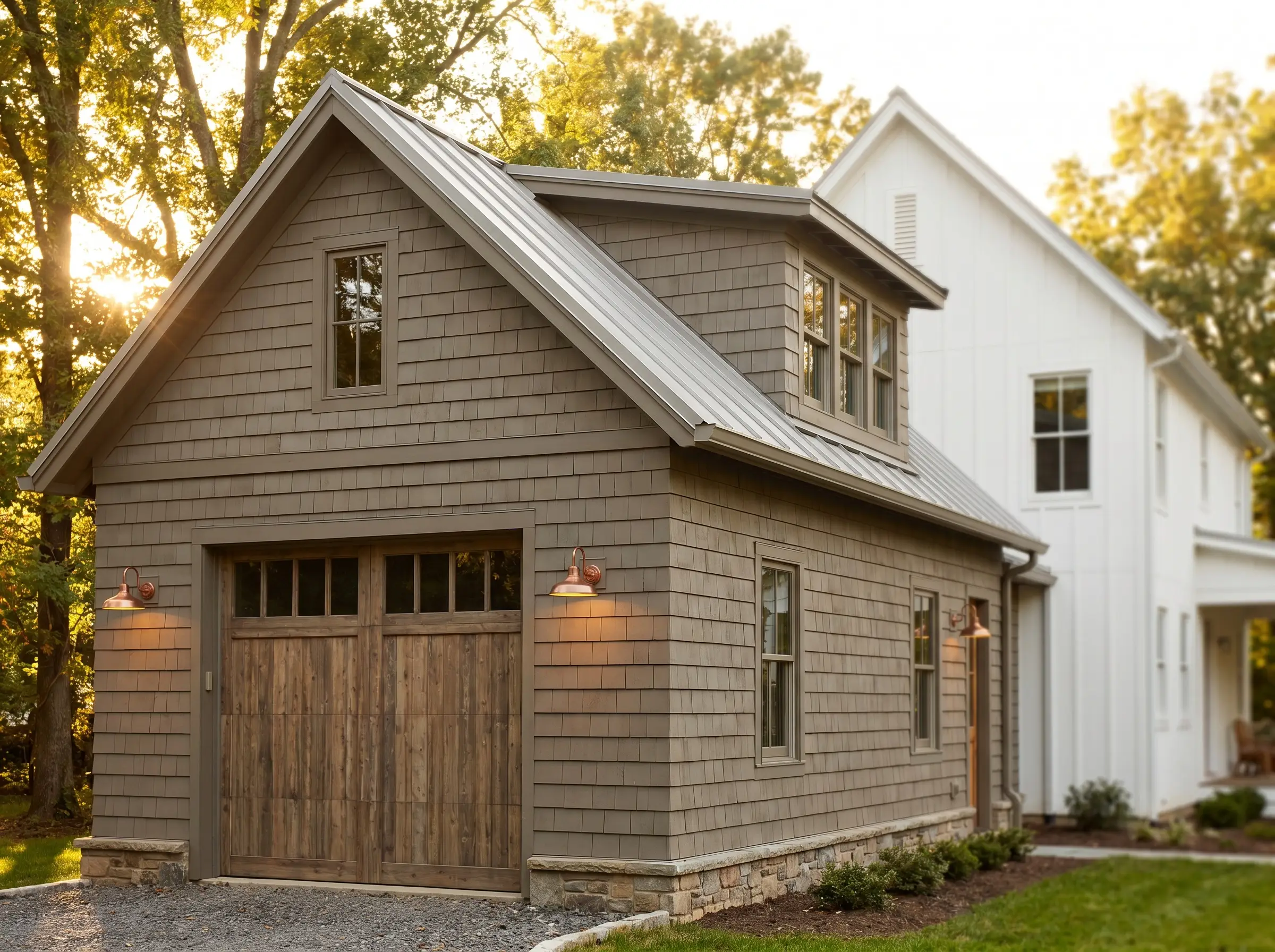 Large expanses of cedar shake siding painted in a muddy dimensional brown-grey anchor a detached guest house featuring a refined wooden garage door.