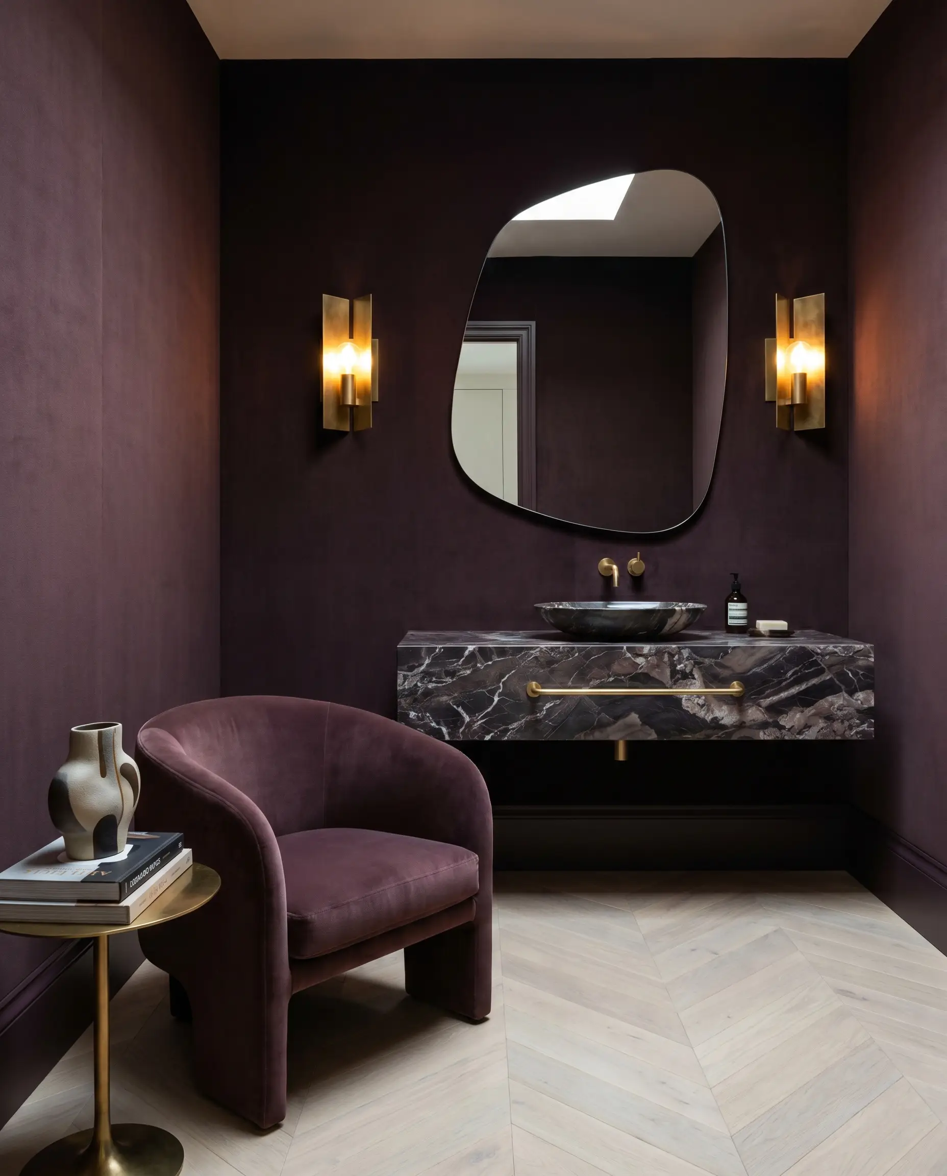 A floating marble vanity and unlacquered brass sconces anchor a postmodern powder room featuring Farrow & Ball Brinjal walls and bleached Scandinavian oak floors.