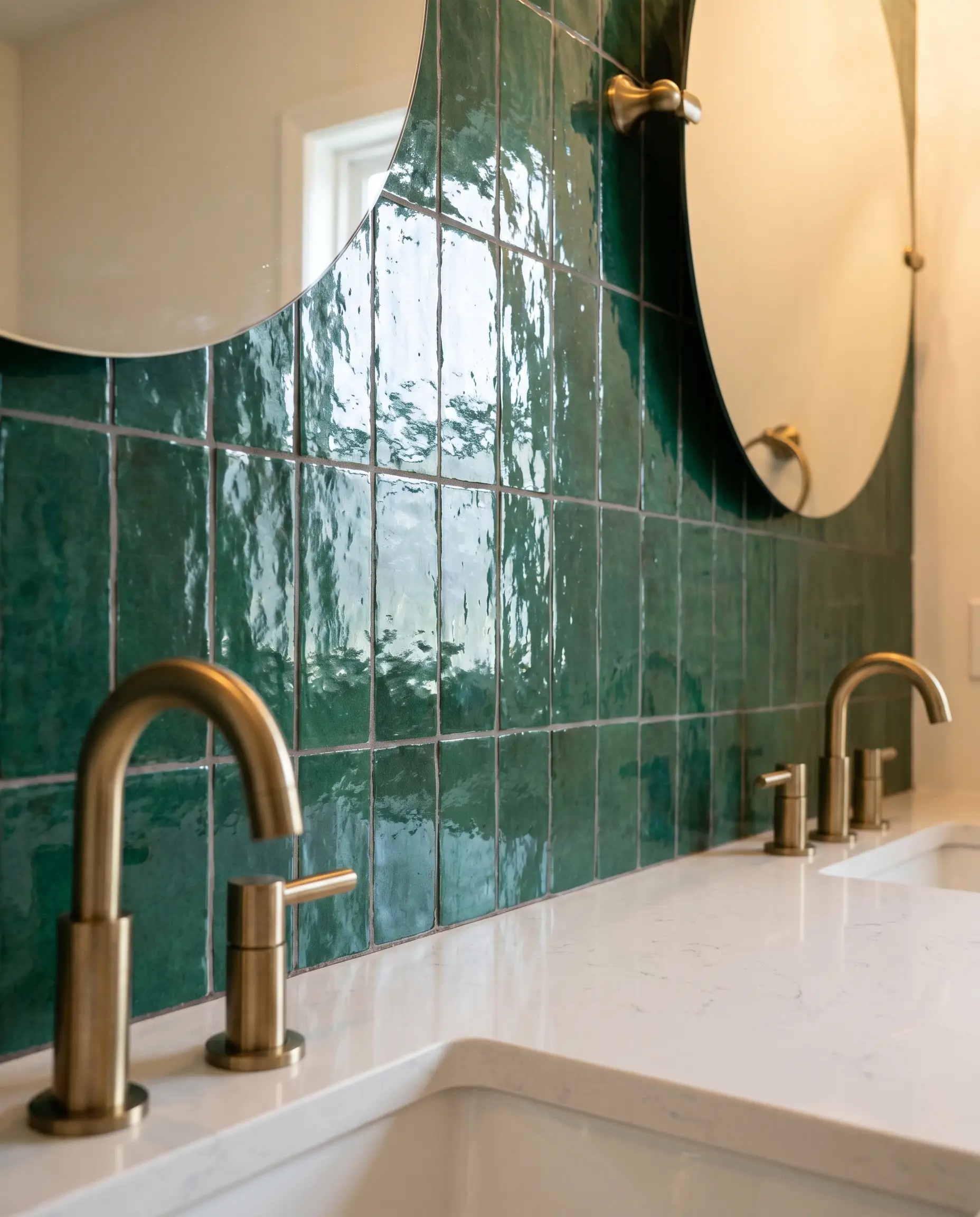 Minimalist brass fixtures protrude above a sleek white quartz countertop against an expertly butt-jointed green Moroccan tile wall utilizing premium non-sanded grout.