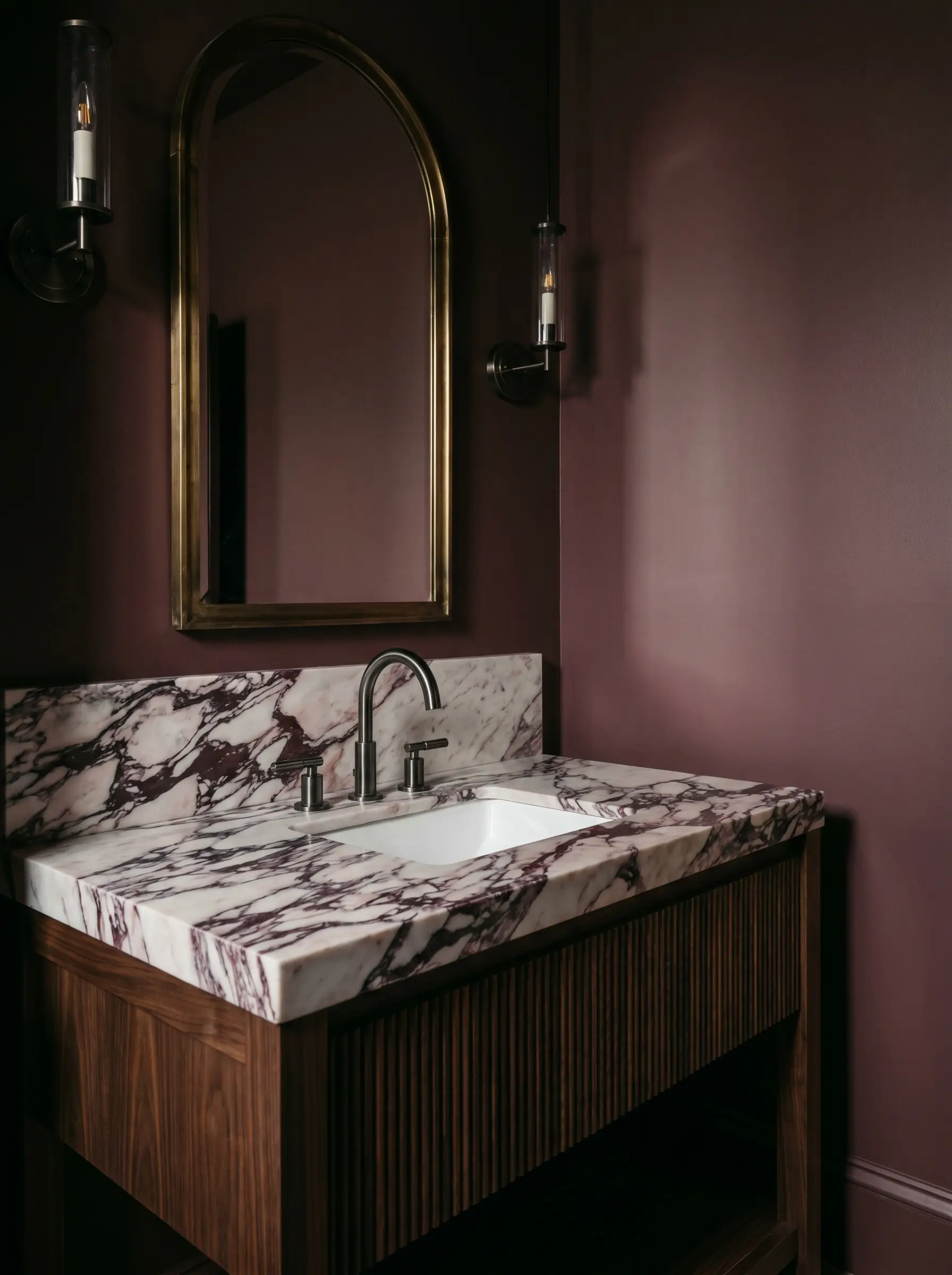 A honed calacatta viola vanity with burgundy veining rests on a reeded dark walnut base against rich Farrow and Ball Brinjal painted walls.
