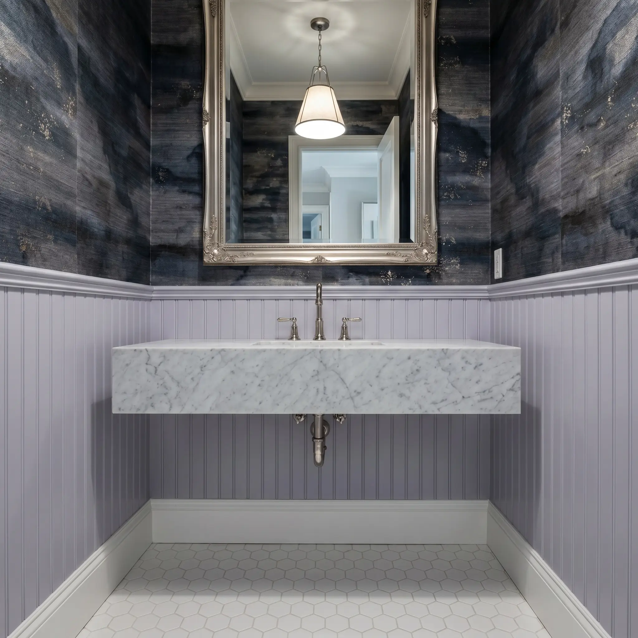 A floating bathroom vanity topped with honed Carrara marble sits against classic beadboard wainscoting painted in French Lilac beneath charcoal watercolor grasscloth wallpaper.
