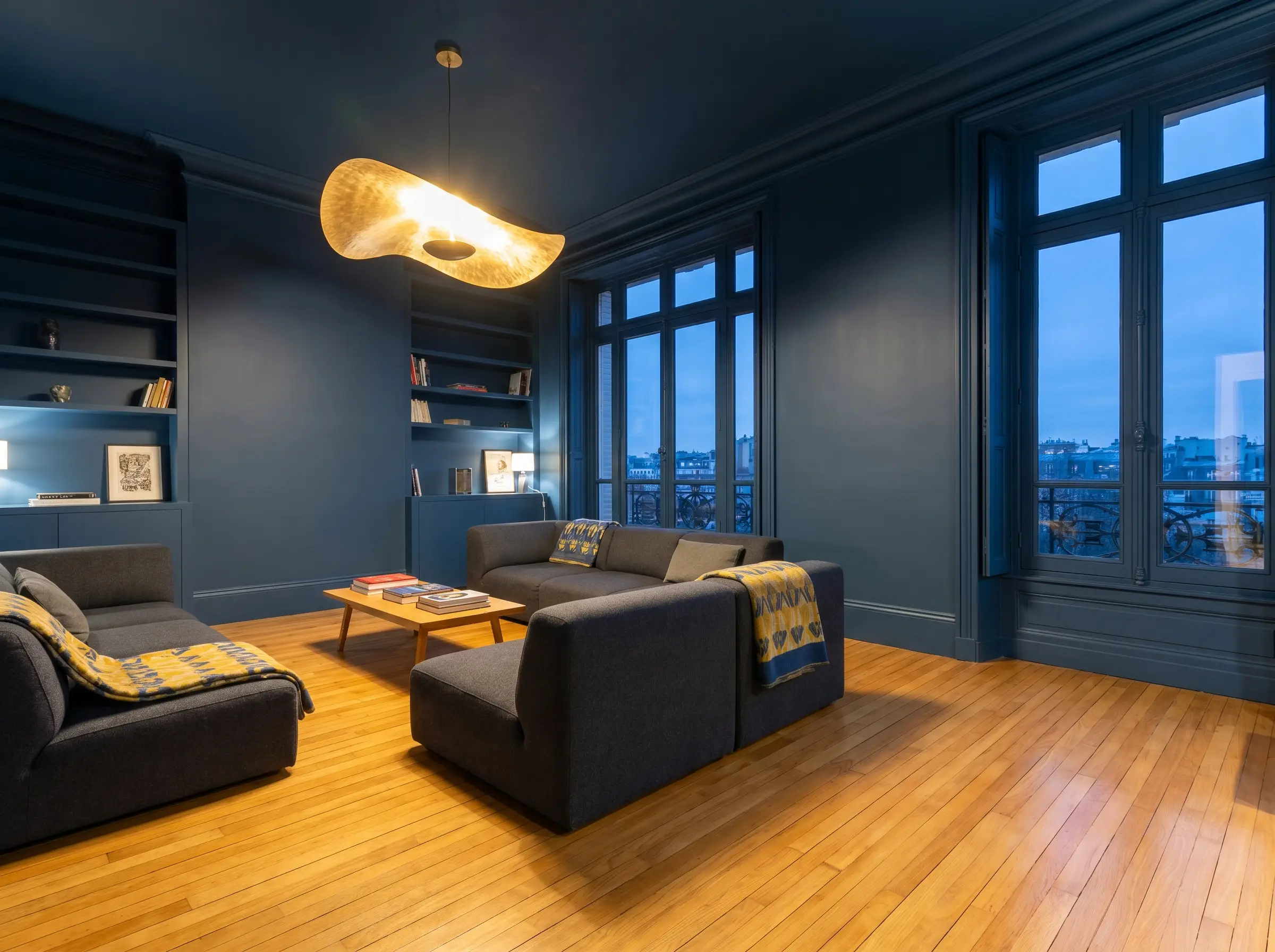 Farrow & Ball Hague Blue color drenching envelops sleek contemporary furnishings, highlighting striking wall colors light oak flooring combinations in this modern living room.