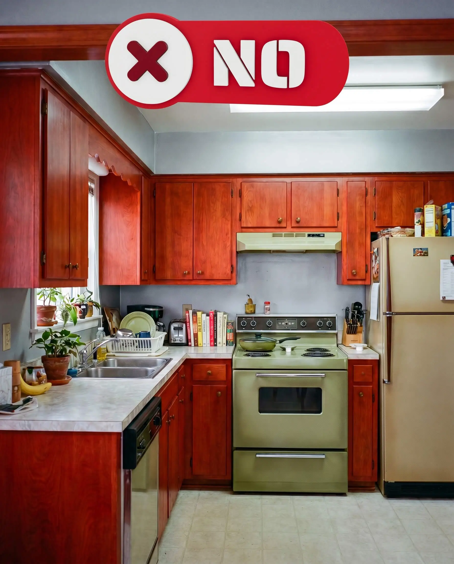 Icy silver-leaning gray painted walls vibrate uncomfortably against intensely warm, red-toned cherry wood cabinets in this severely mismatched kitchen space.