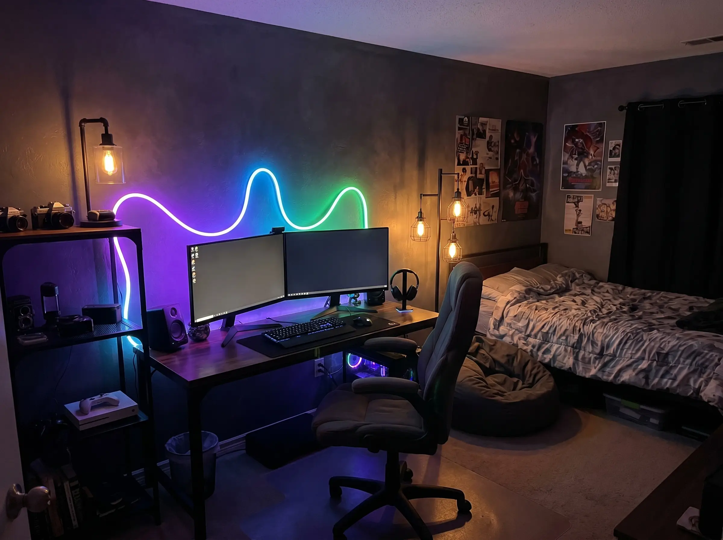 Diffused RGB neon-rope lights cast a soft ambient glow onto the dark painted walls directly behind a dual-monitor gaming desk setup.