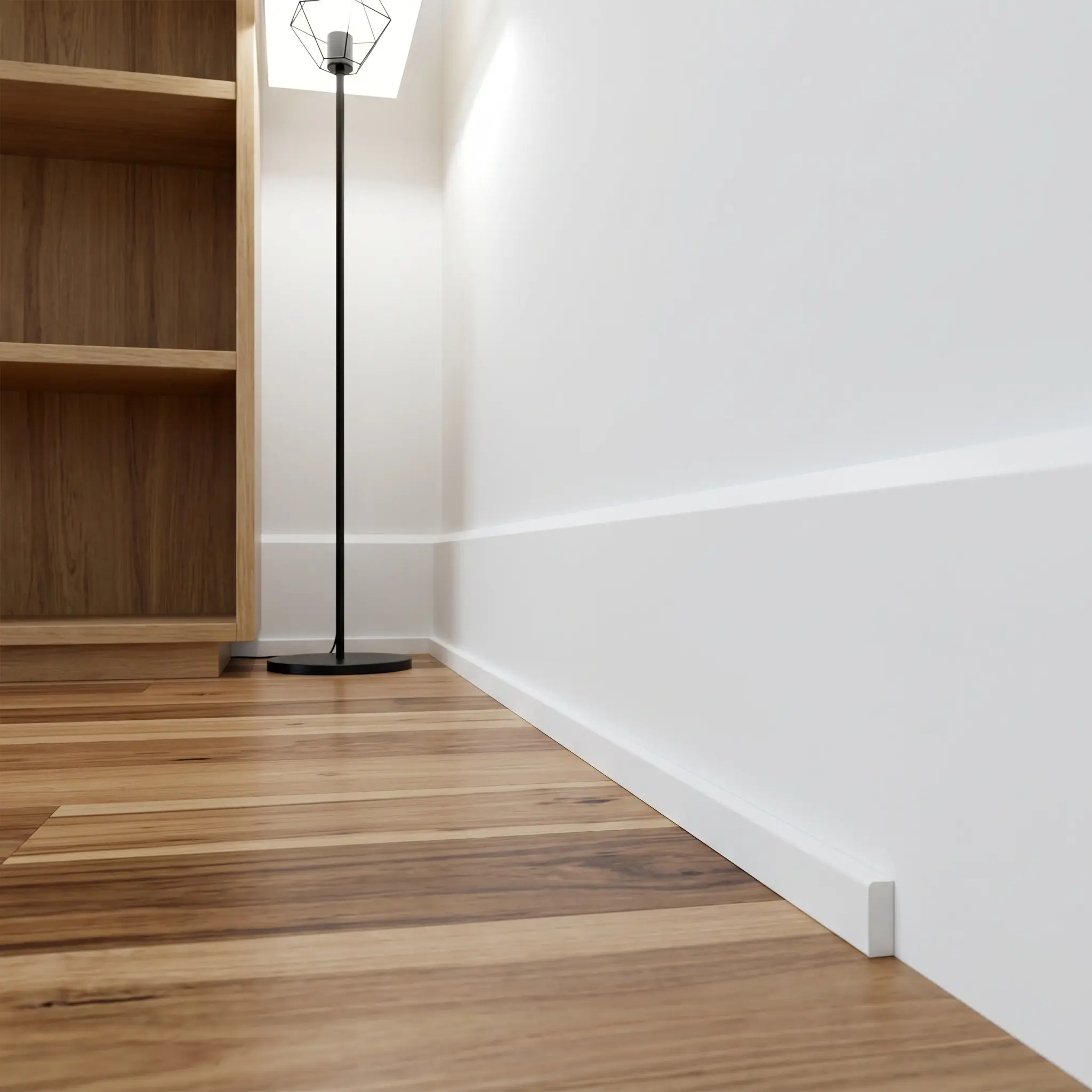 A crisp flat stock baseboard pairs with rectangular shoe molding to cover the expansion gap of a natural hickory hardwood floor beneath a wooden bookshelf.