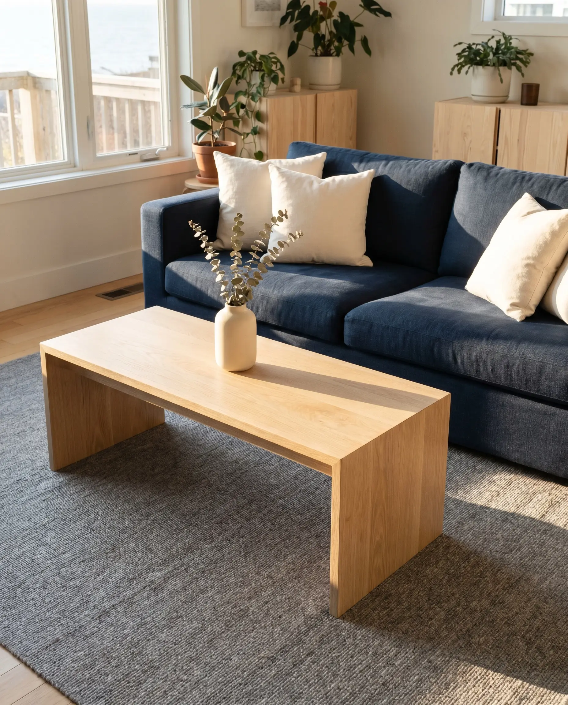 A light rift-sawn white oak centerpiece offers excellent coffee tables to match a navy blue sofa, floating above a heathered gray wool rug.